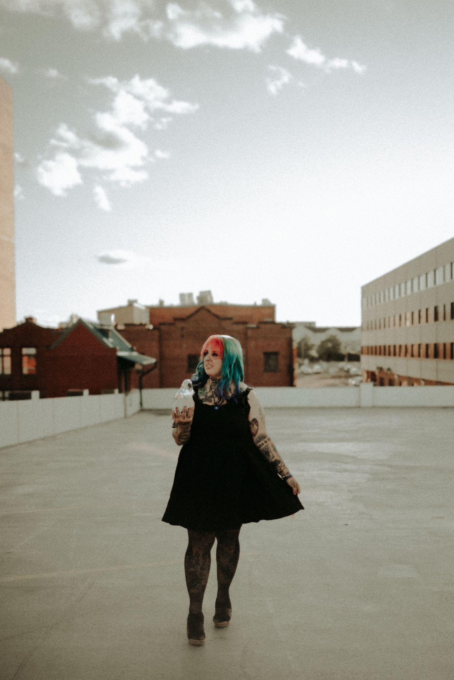 A sequence of five photos shows a figure in black clothing walking across an empty urban rooftop against a cloudy sky.