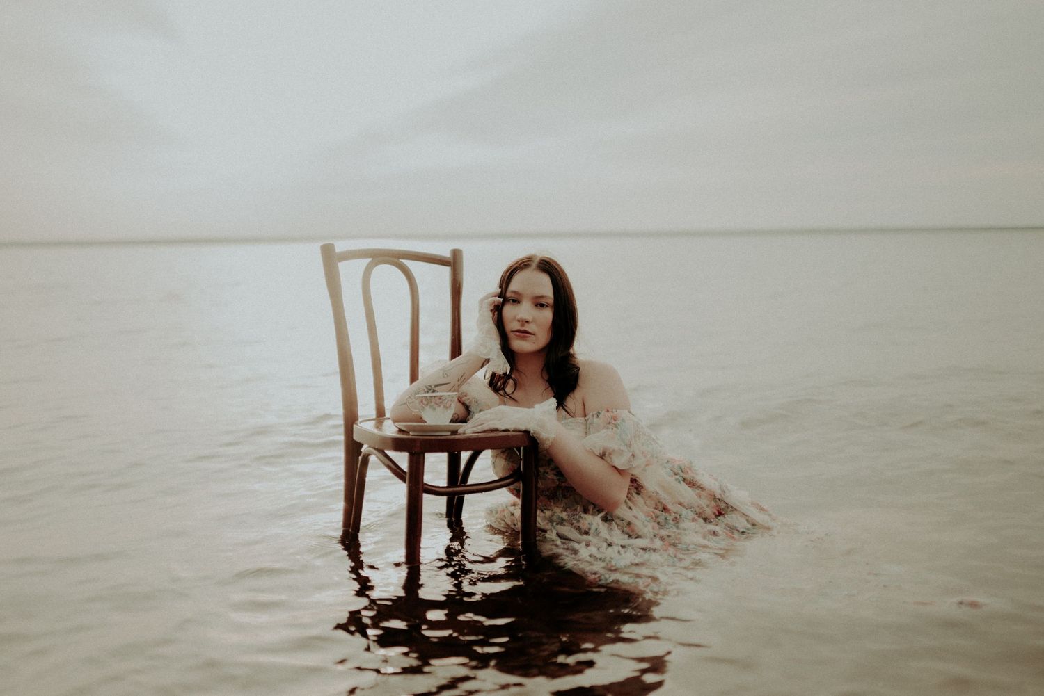 Artistic portrait series with wooden chair in shallow water.