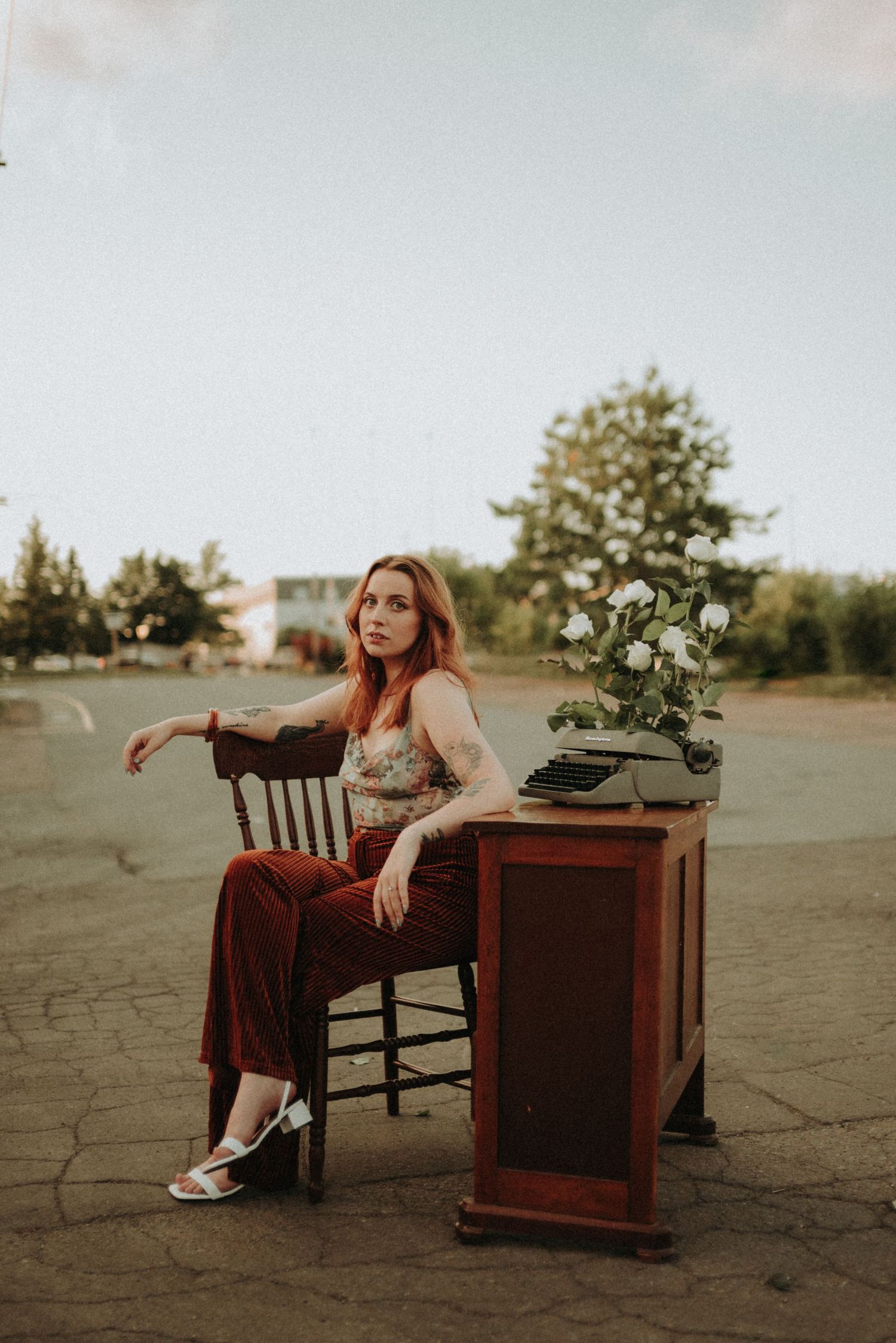 Retro aesthetic portrait with antique desk and typewriter in golden afternoon light.