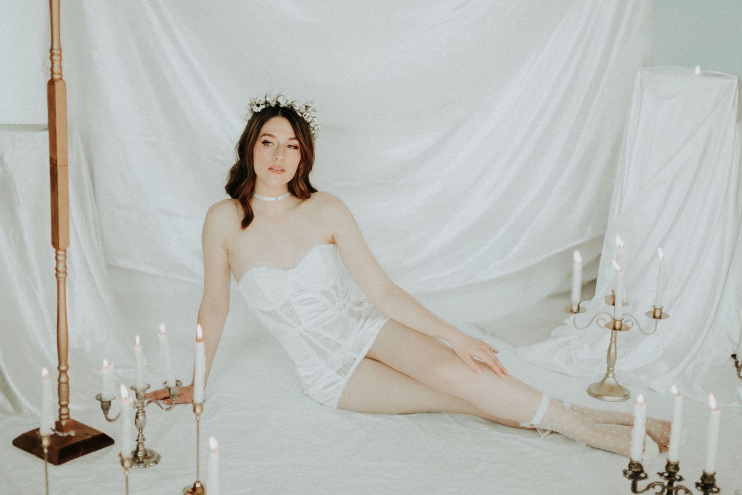 A romantic wedding photo series with candlelit settings and white fabric backdrops featuring elegant bridal poses.