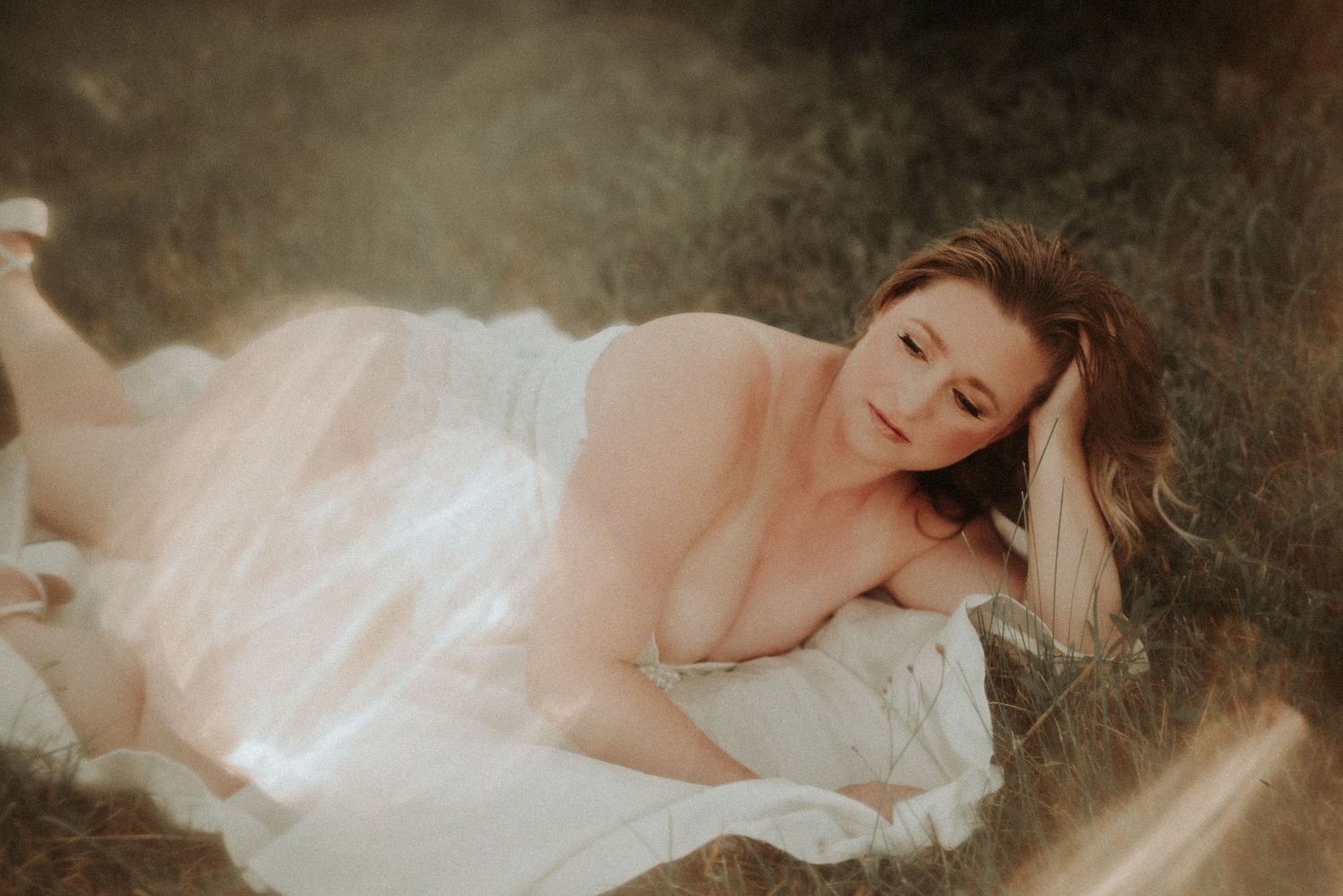 A dreamy boudoir photo series shows a figure in white reclining against dark moody backgrounds.