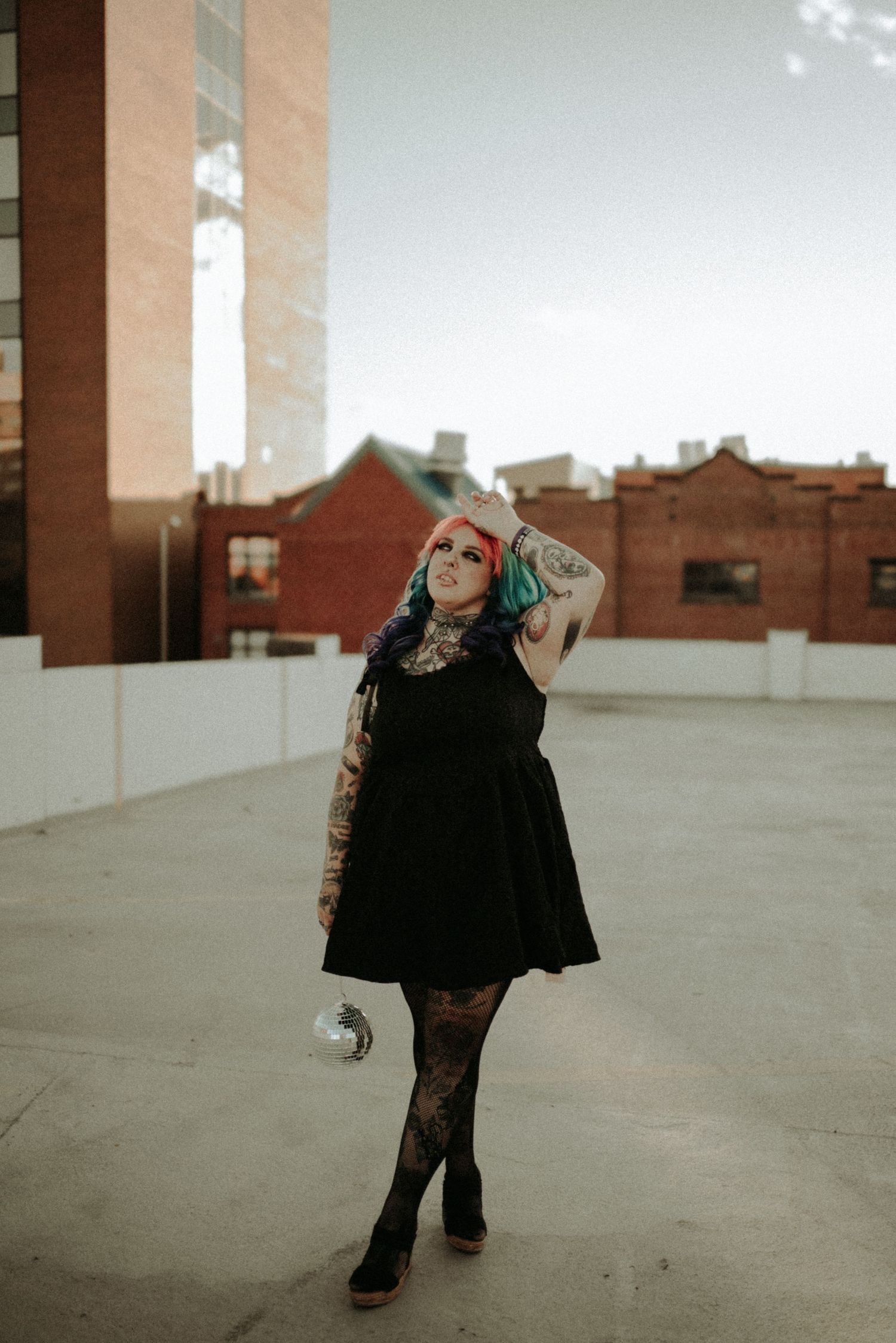 A person in black clothing dances and spins across an empty rooftop space in a series of connected motion shots.