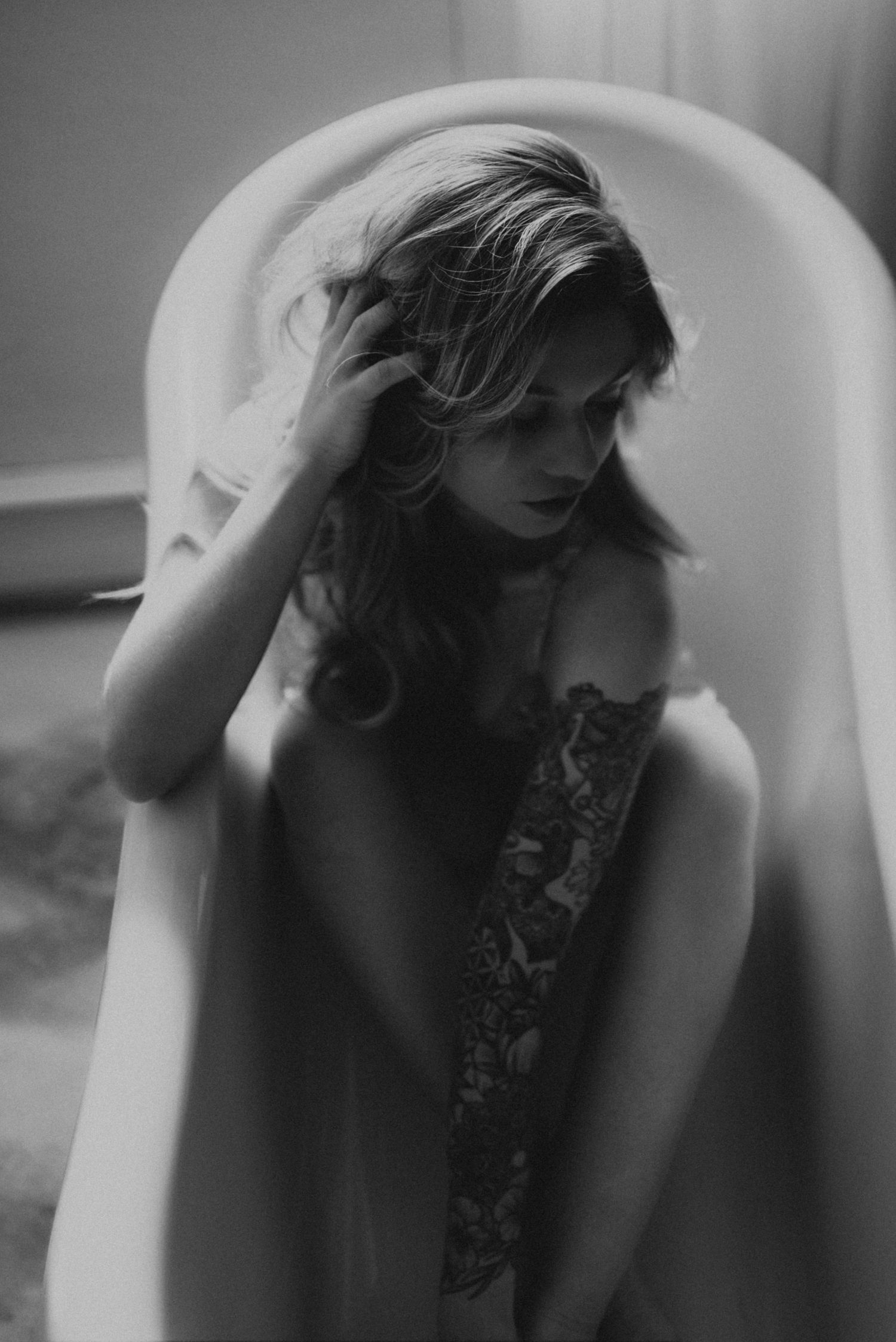 Black and white photo series showing woman reclining in bathtub, captured in dreamy artistic style.
