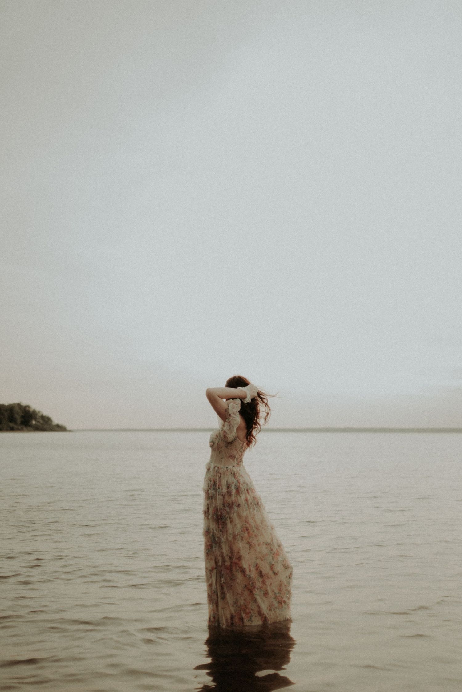 An artistic water portrait with a flowing dress against a minimalist horizon.