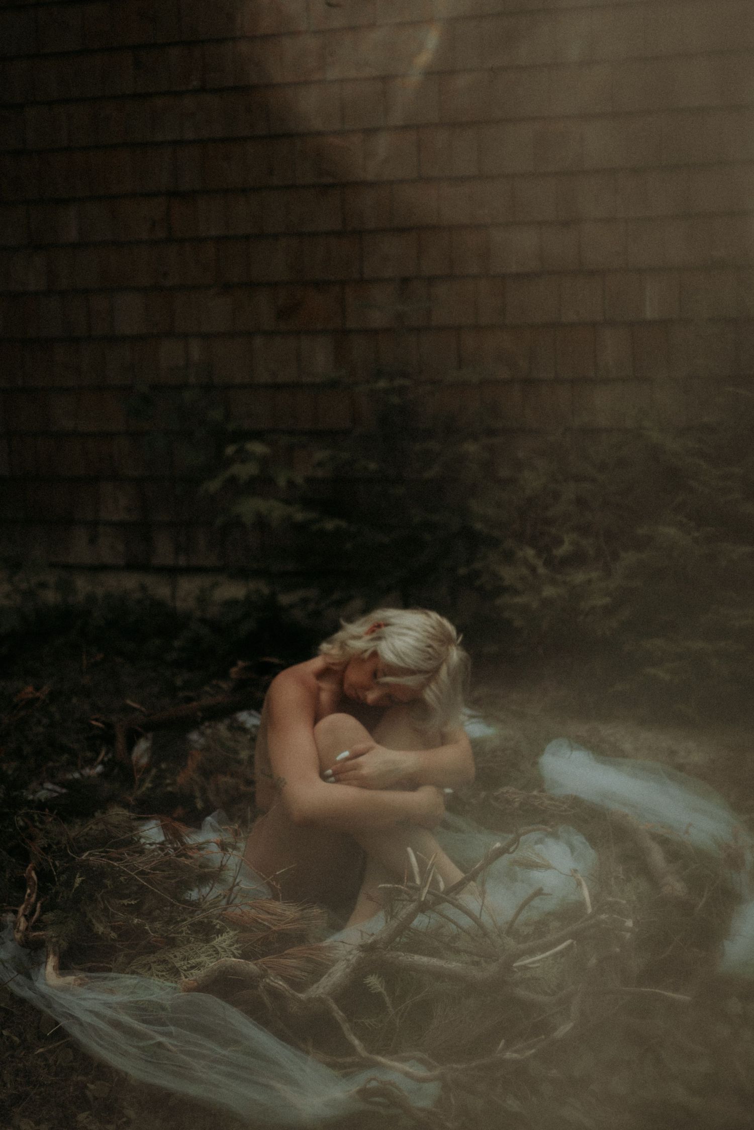 Dreamy artistic portrait on fabric with dramatic lighting and natural elements.