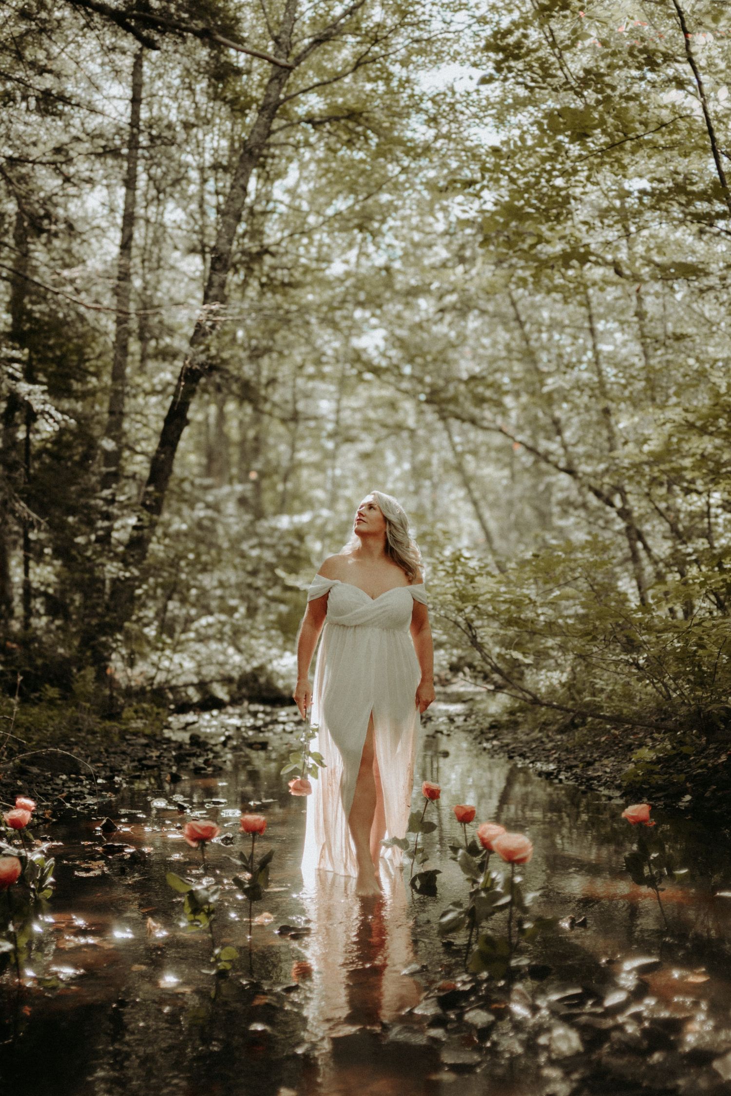 Artistic photo series showing a figure in white dress moving through a misty forest with scattered flower petals.