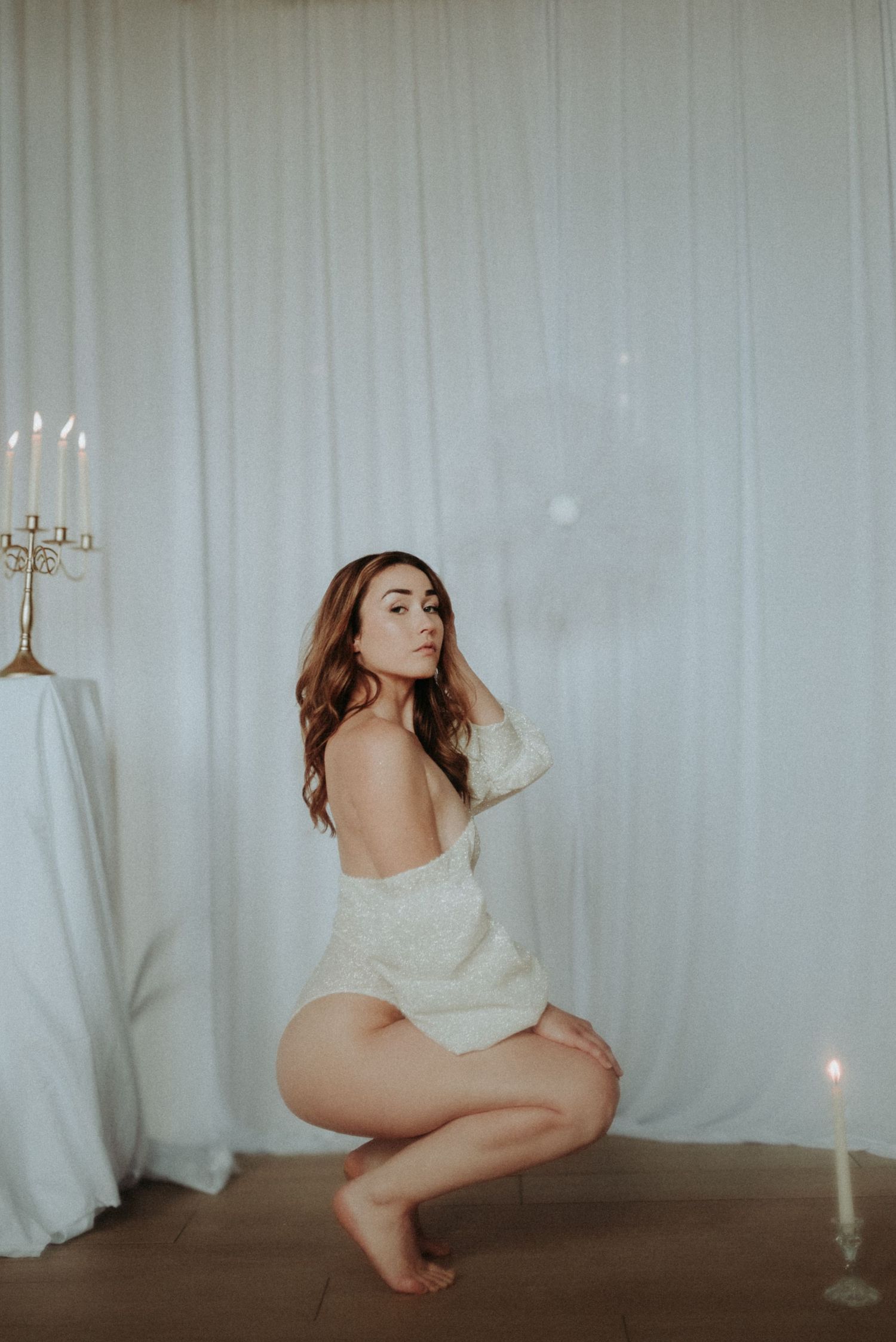 A series of artistic boudoir photos showing a figure draped in white fabric against a light backdrop.