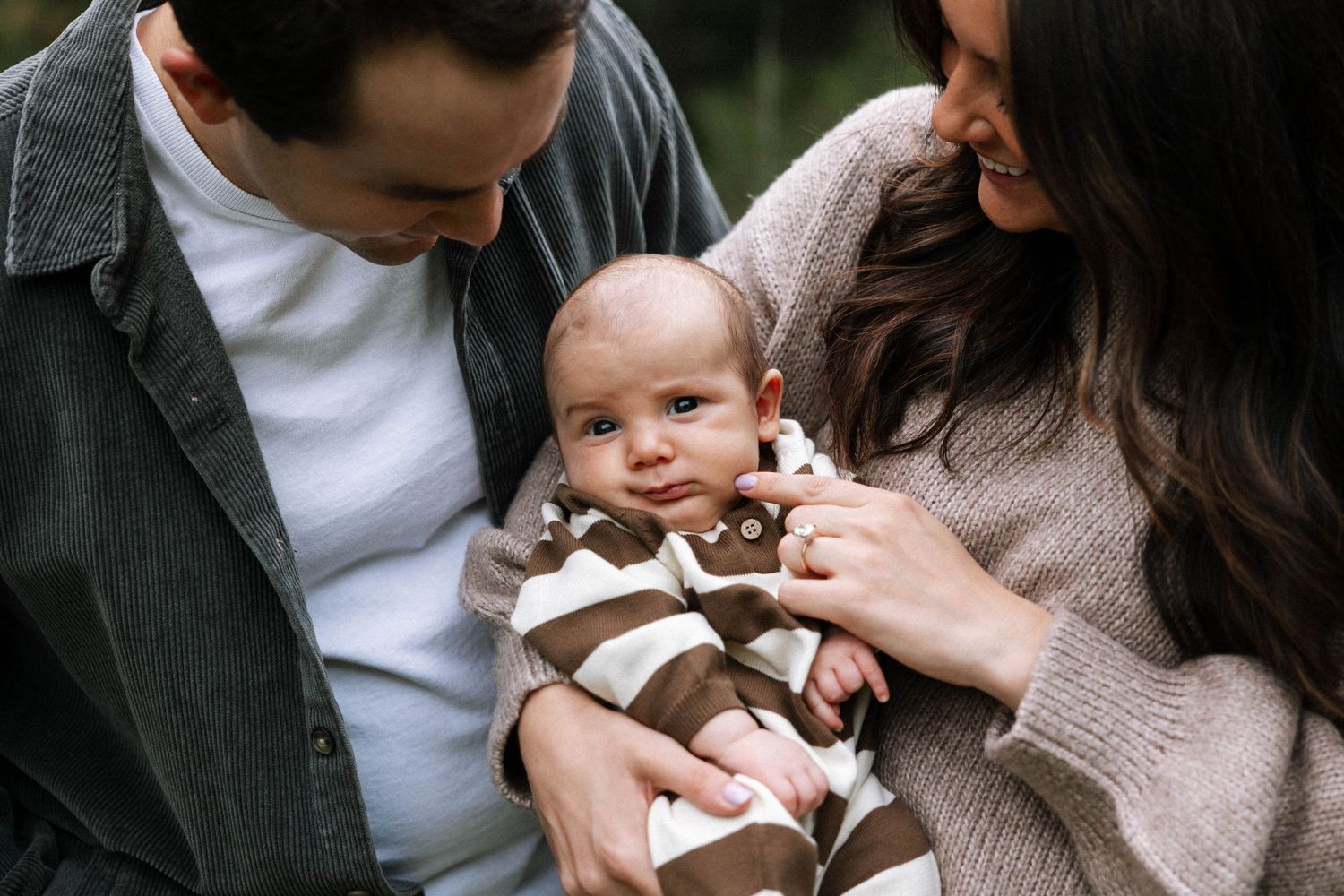 Intimate family portrait with new baby in cozy neutral tones.