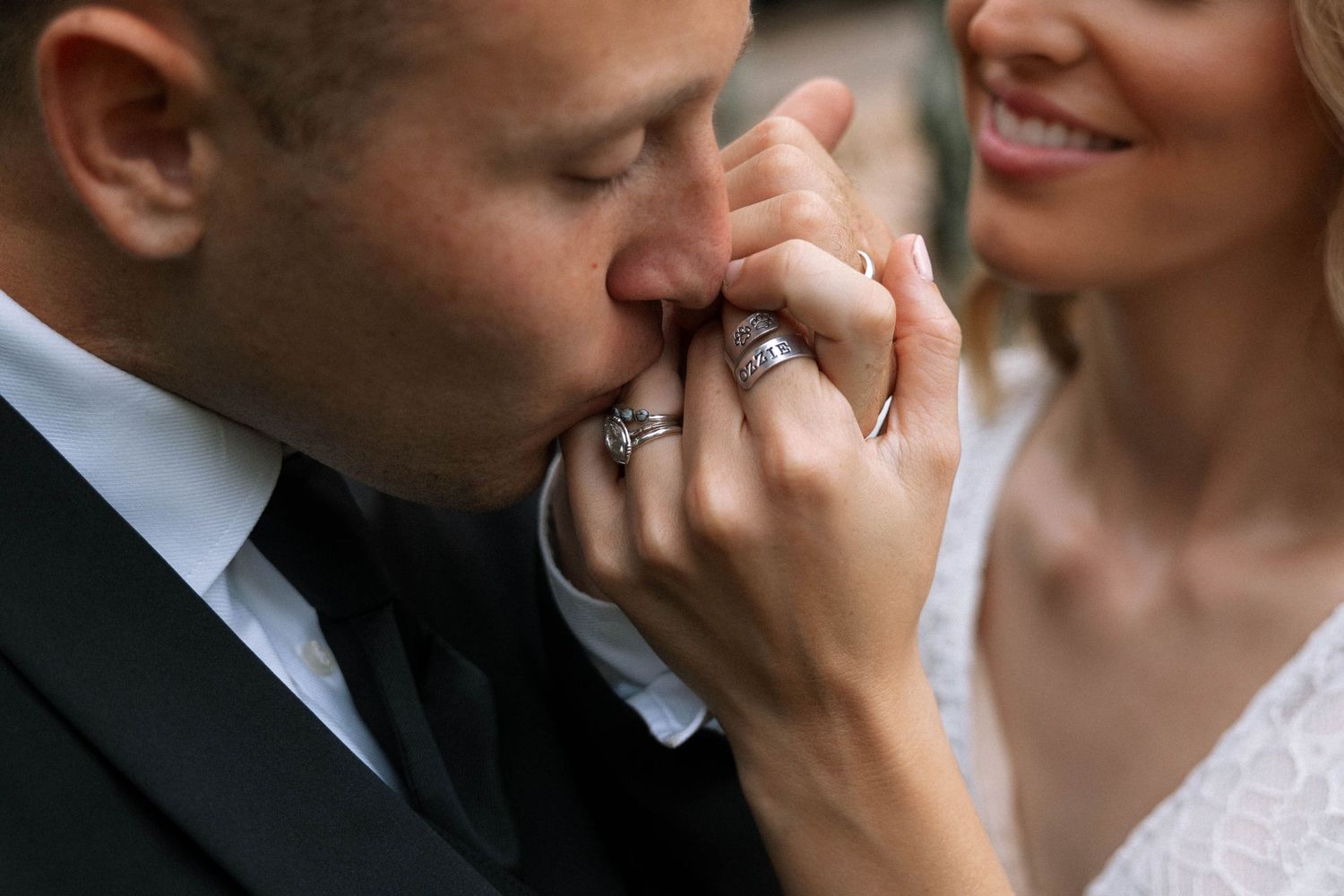 Close-up photo of wedding ring details with romantic gesture.