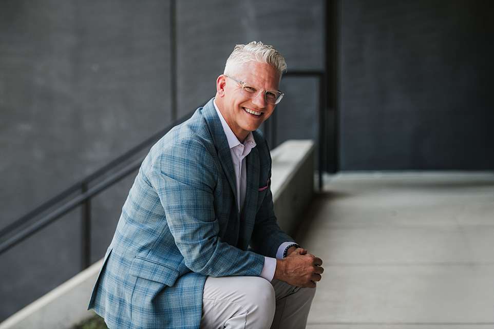 Professional business portraits in modern office setting with grey walls.