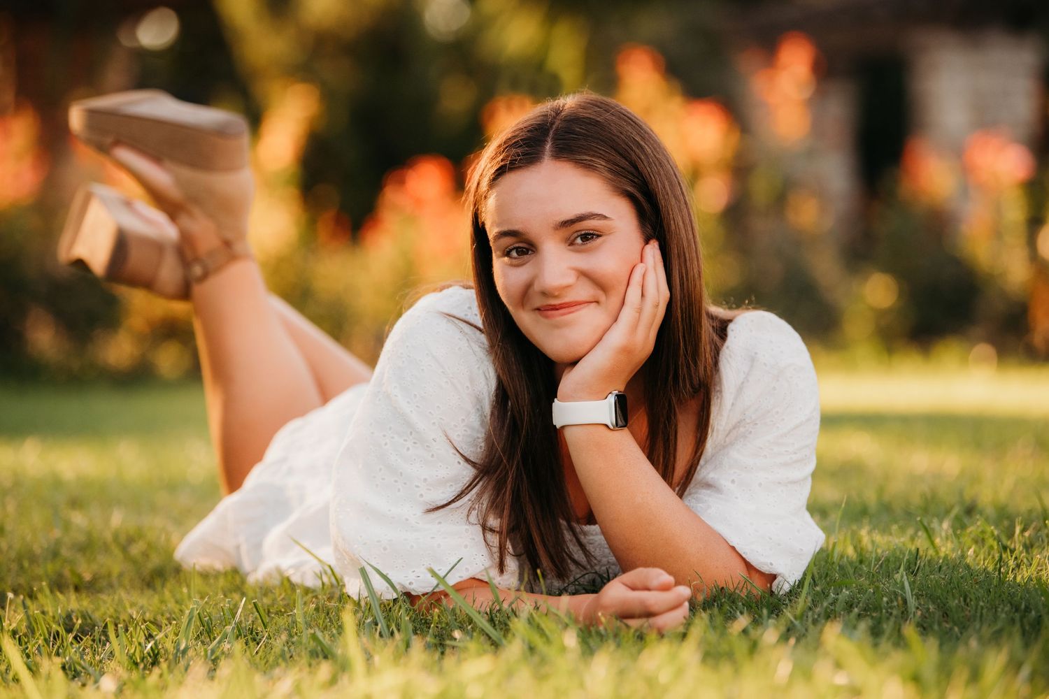 Sunset portrait session on grass with natural golden hour lighting.