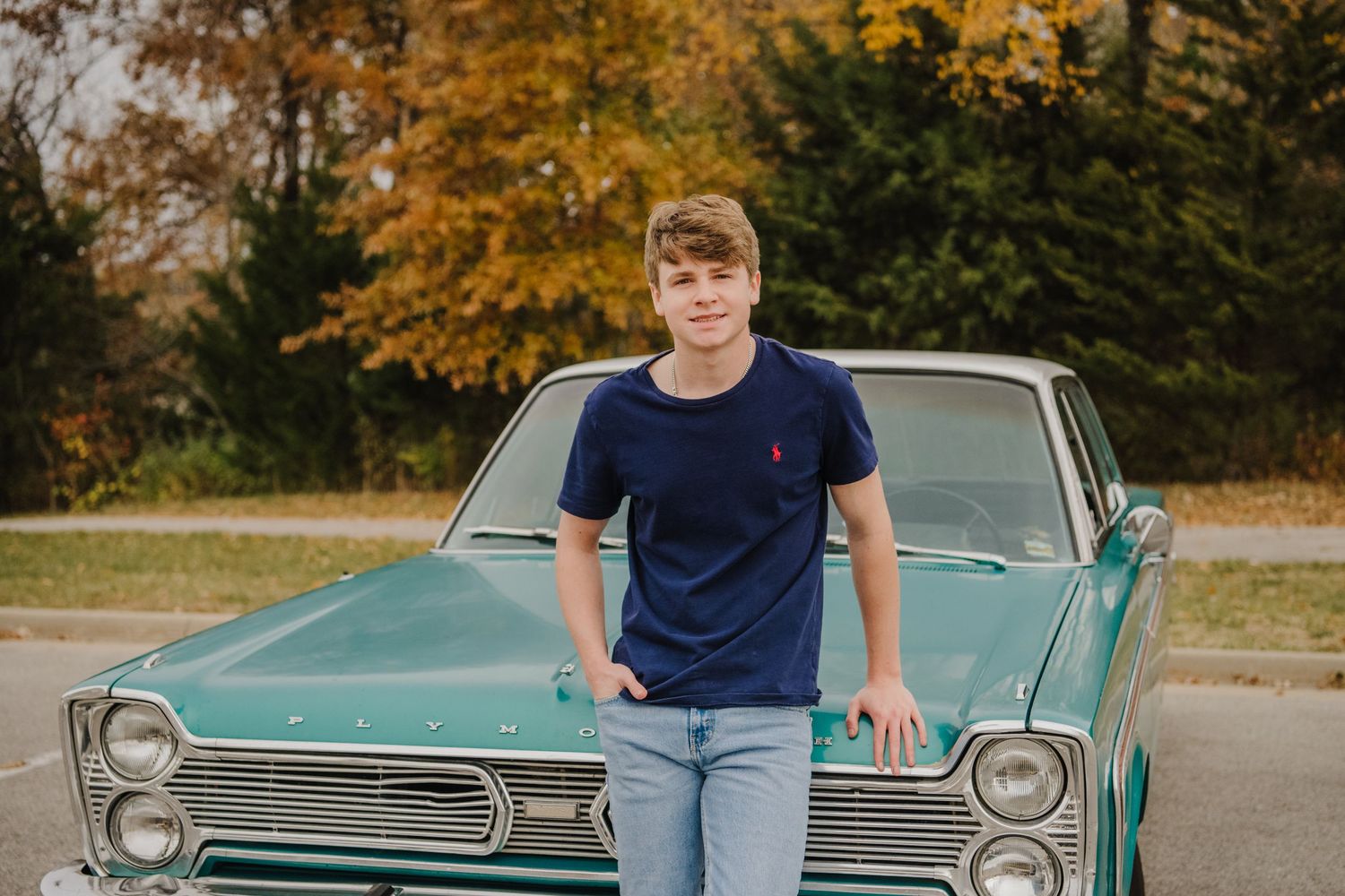 Vintage teal classic car serves as backdrop for casual outdoor portrait session.