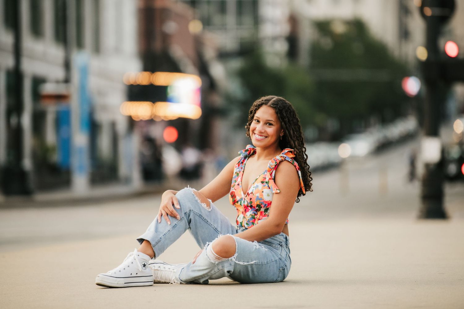 Urban street photography session with distressed jeans and casual style against city backdrop.