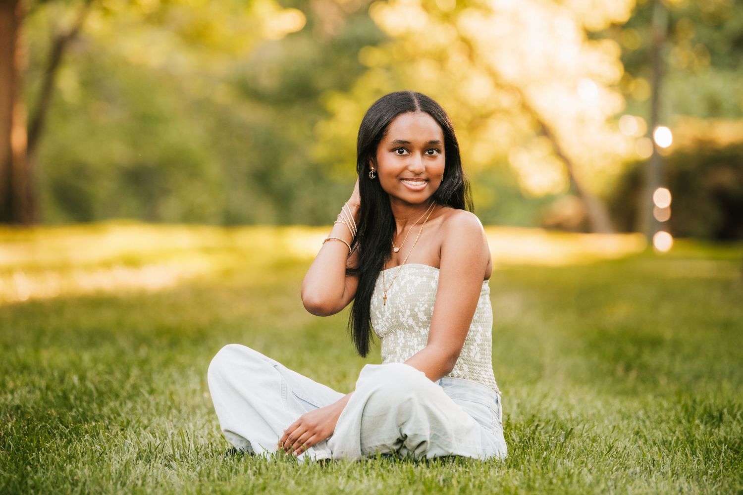 Outdoor portrait session on grass during golden hour in formal white dress.