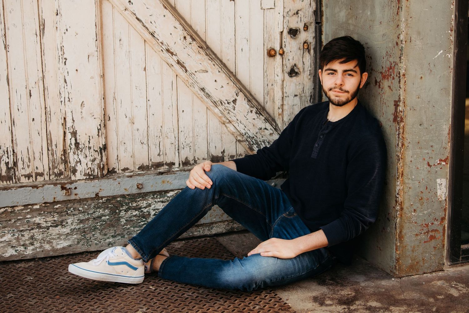 Relaxed portrait session against weathered white wooden door background.