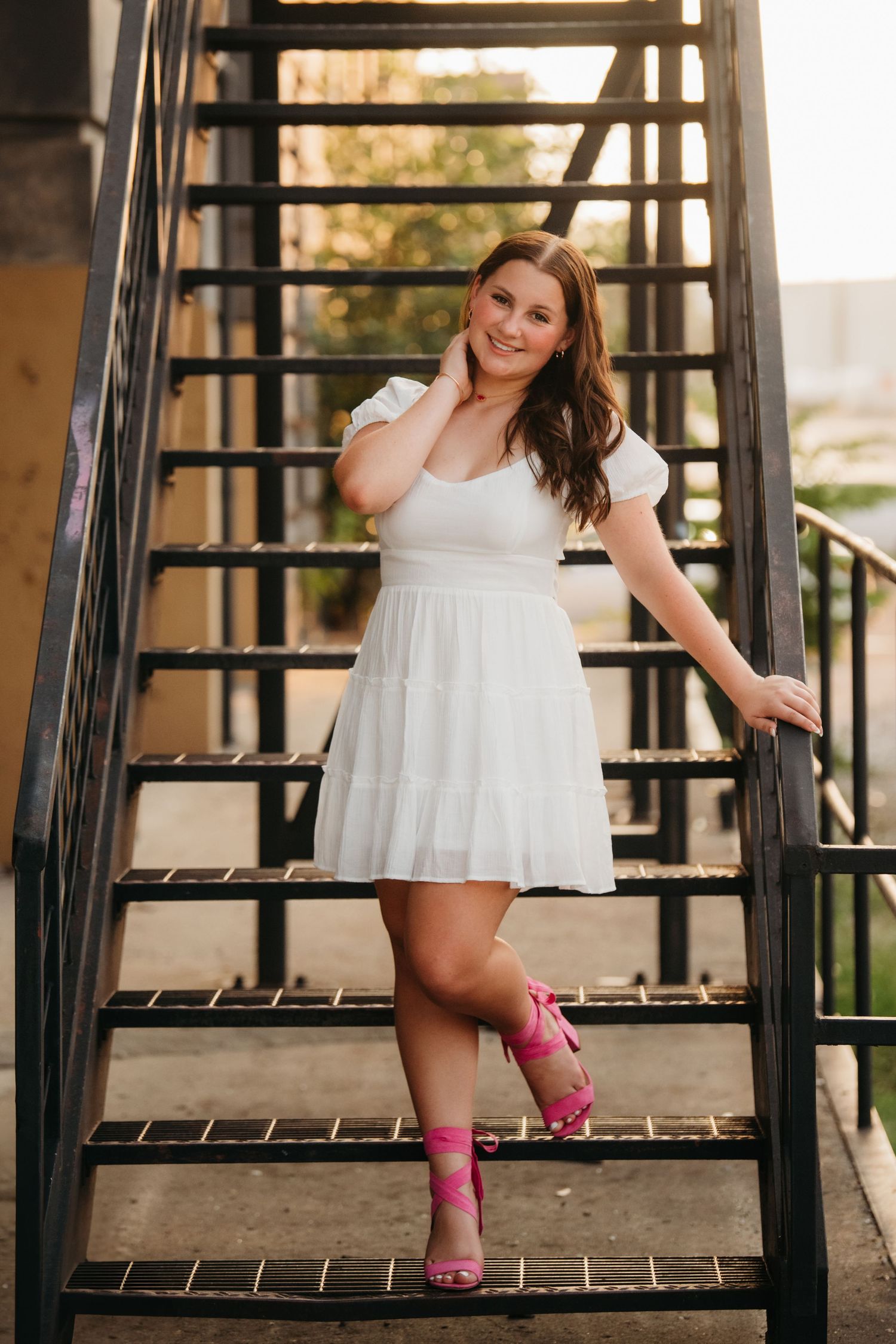 A series of portrait photos on a metal staircase featuring a white summer dress and pink heels.