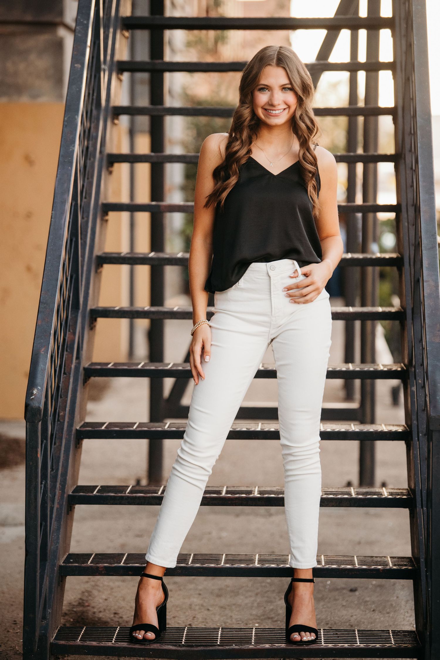 Fashion portraits on metal stairs showing casual black and white outfit combinations.