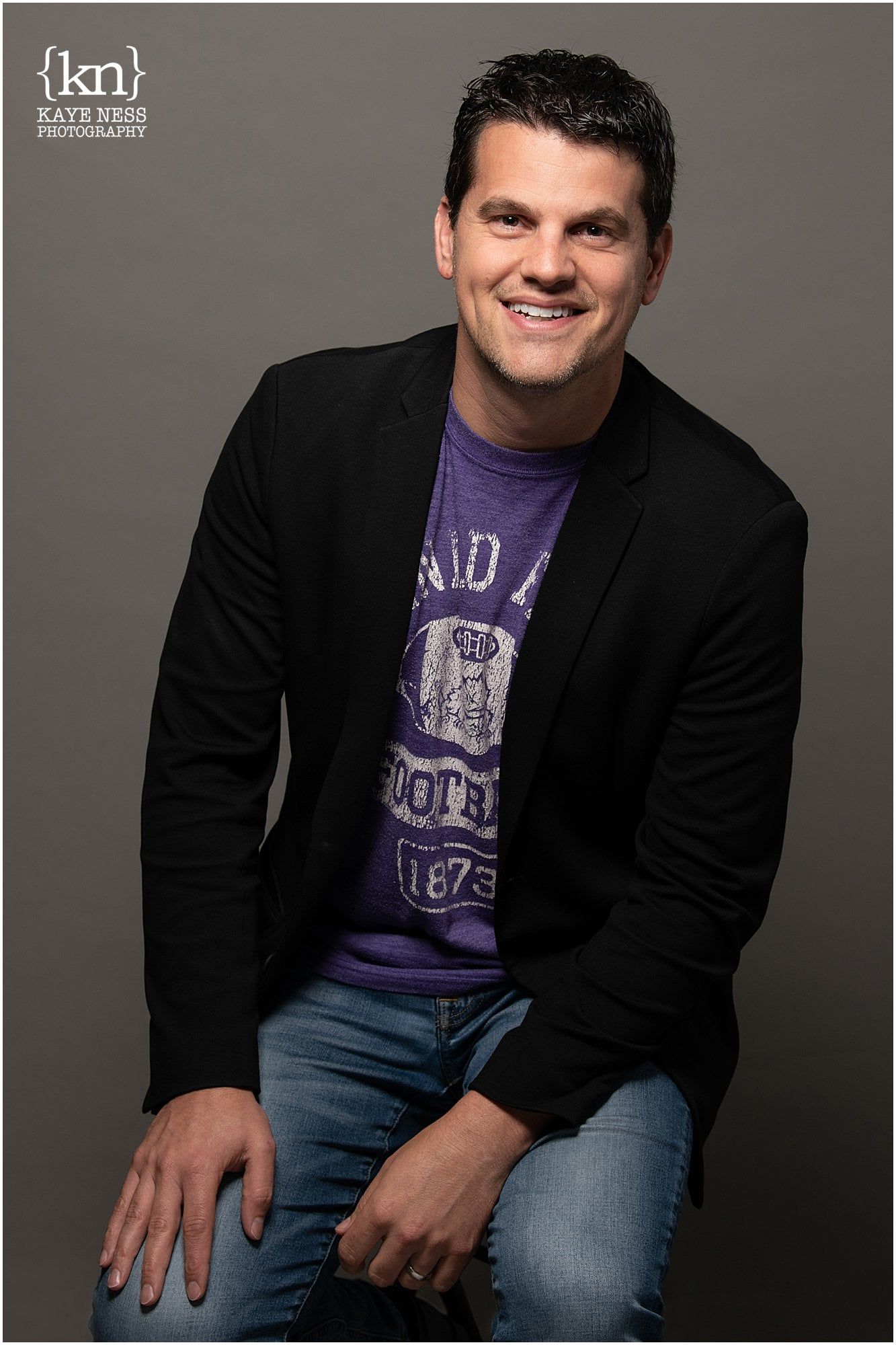 Professional headshots of person in black blazer and purple shirt against gray background.