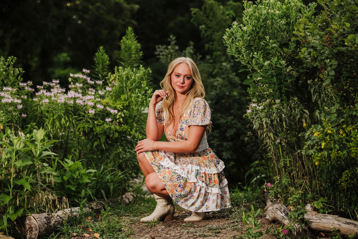 Romantic garden photography with flowing floral dress among lush summer greenery.