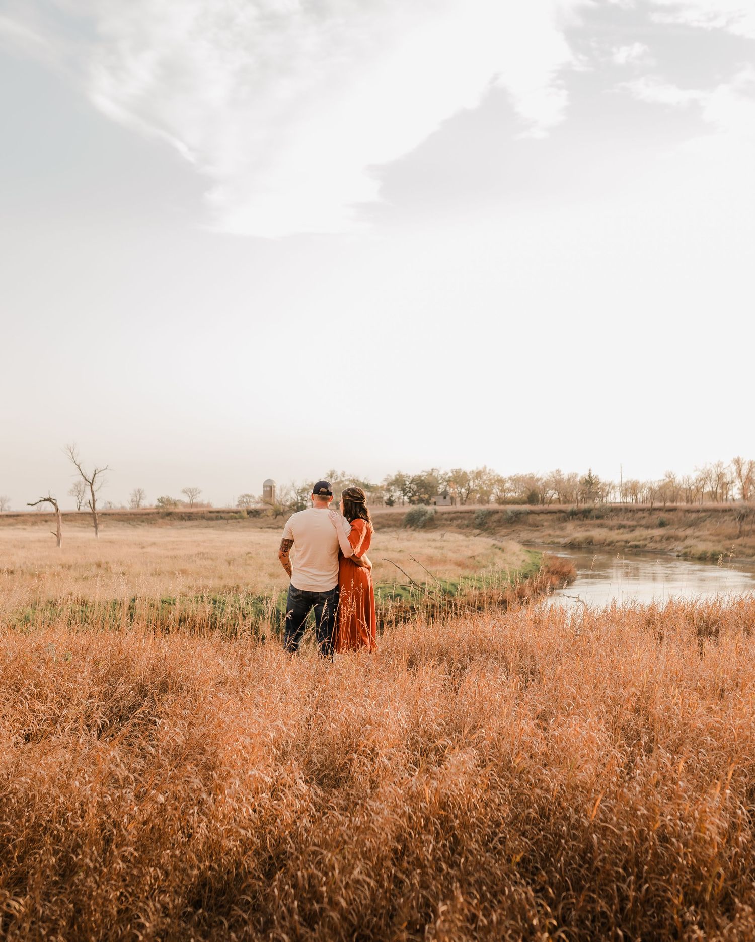 Engaged couple during fall photo session near Redfield, South Dakota with bride in red dress