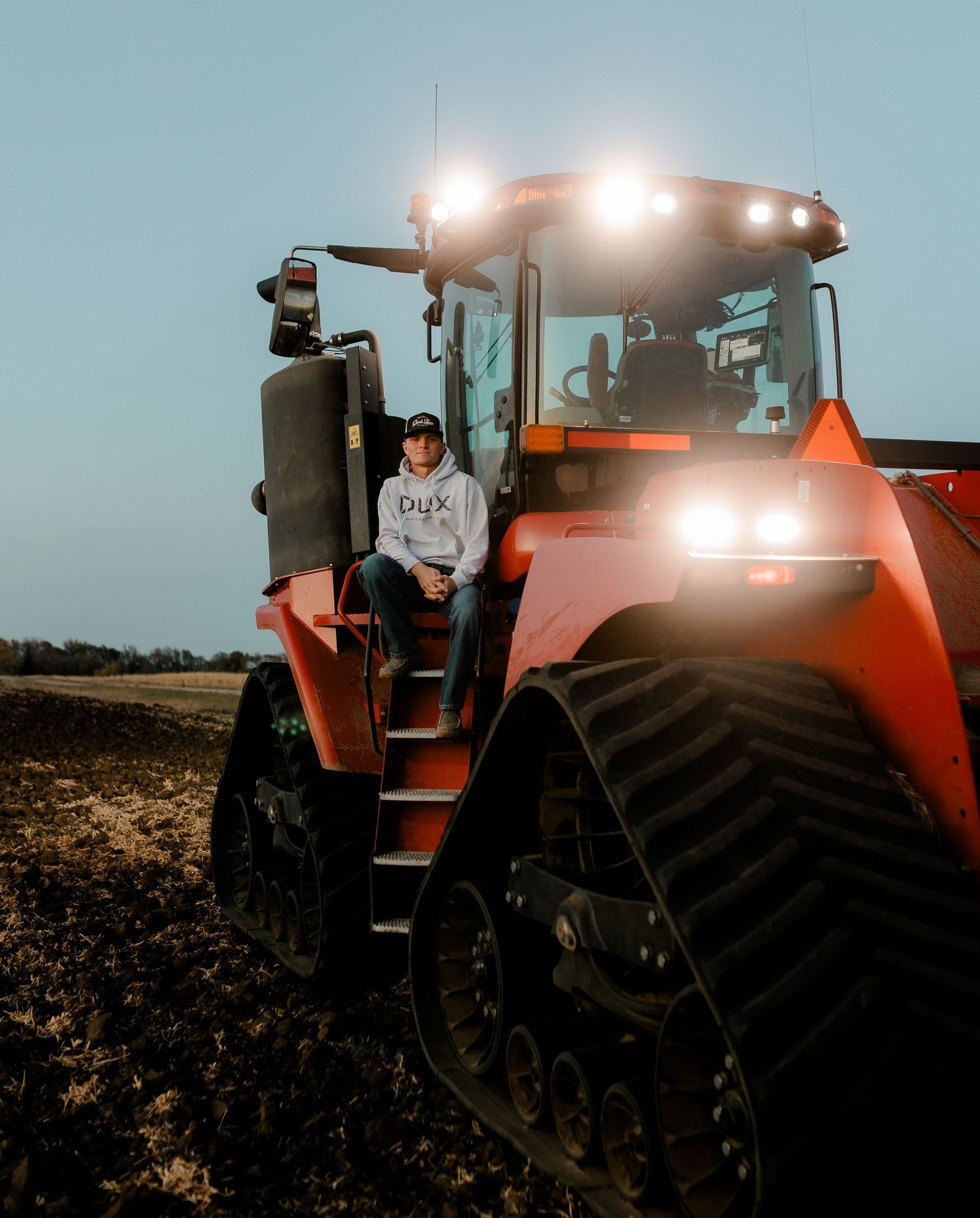 High school senior boy on family farm near Willow Lake, South Dakota with tractor and hunting gear
