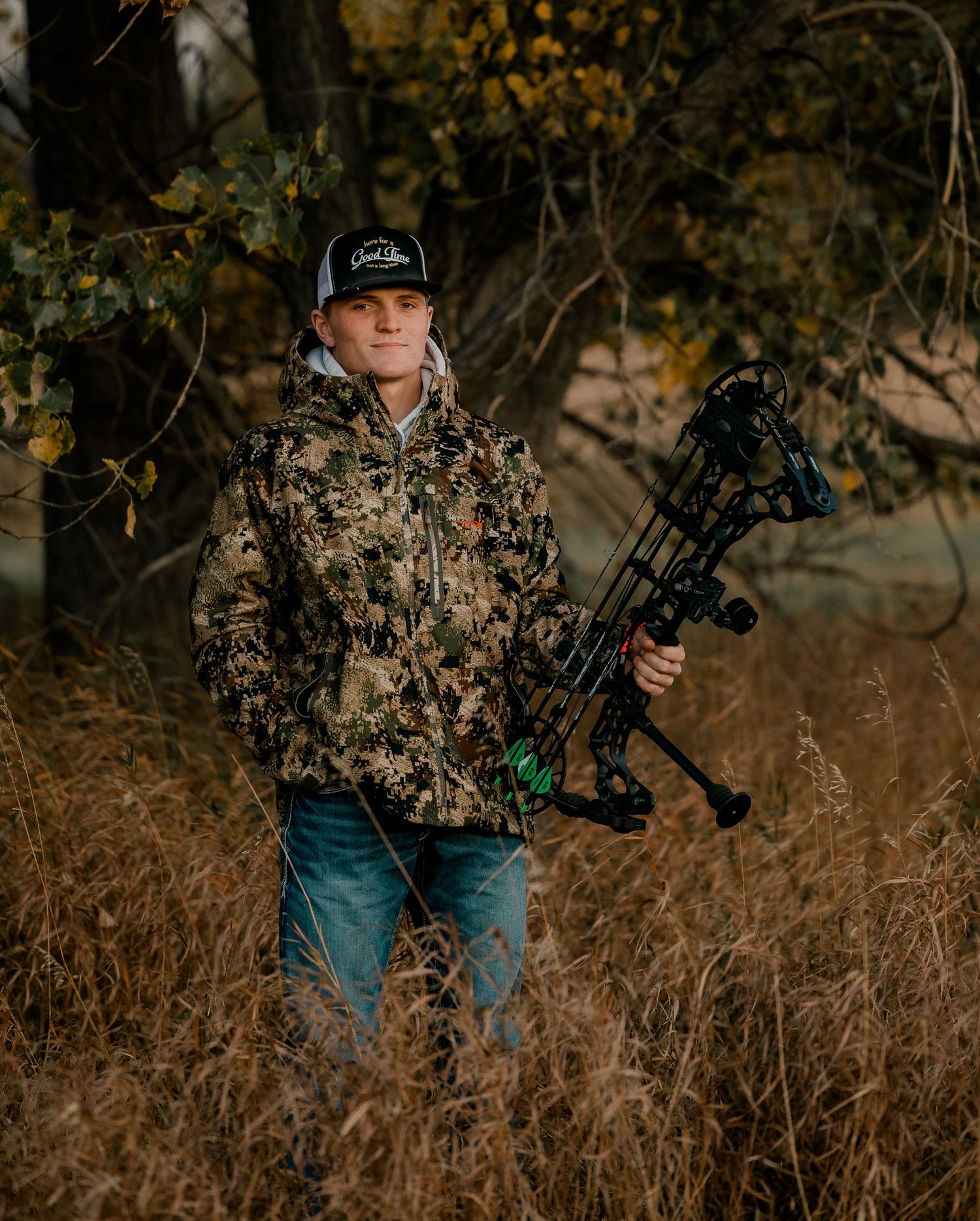 High school senior boy on family farm near Willow Lake, South Dakota with tractor and hunting gear