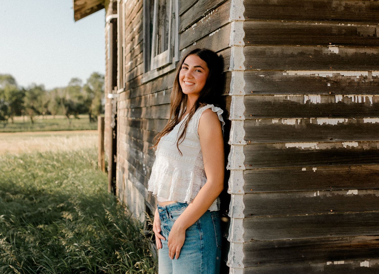 Outdoor senior portrait with soft natural light and relaxed pose