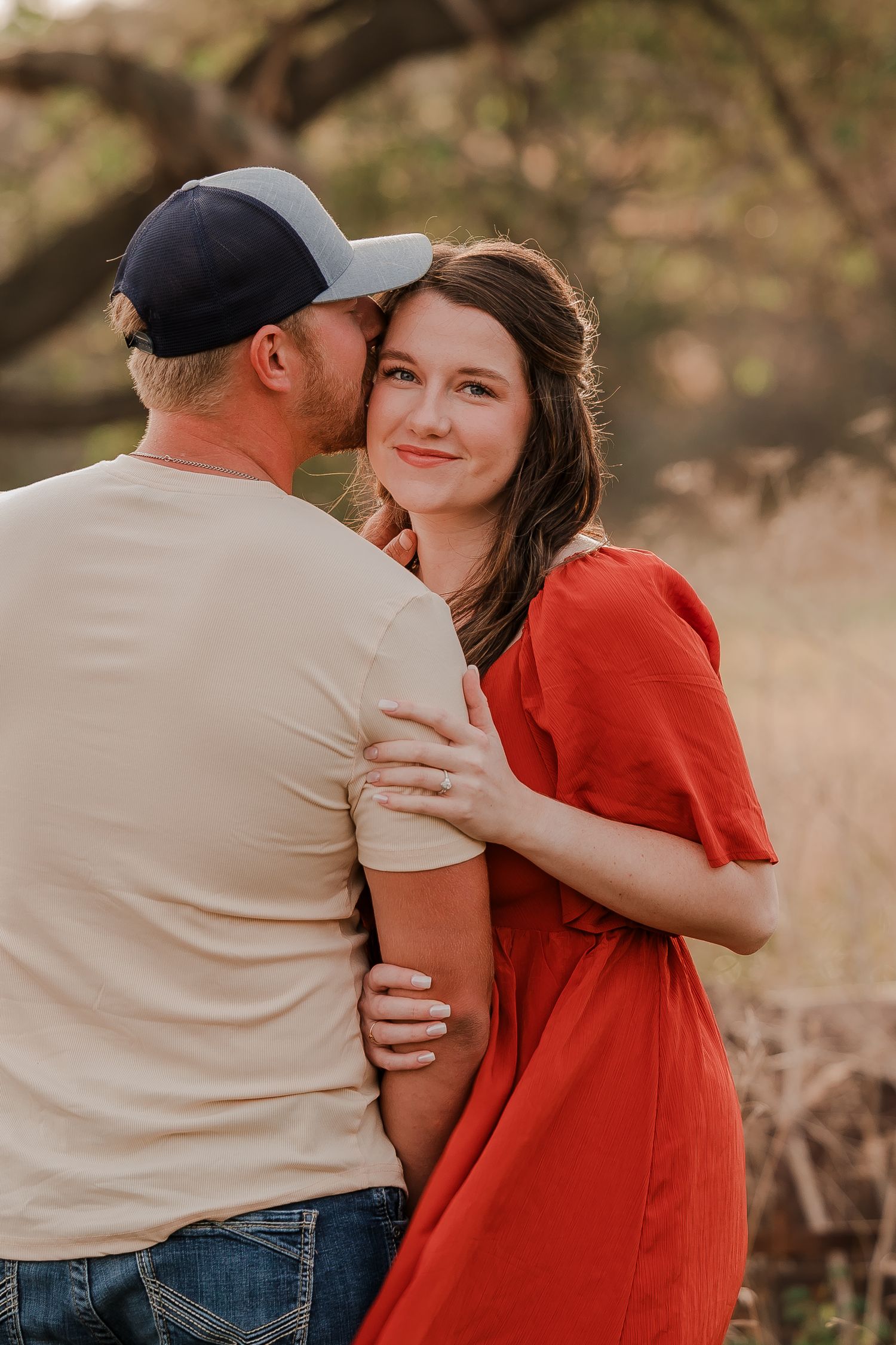 Engaged couple during fall photo session near Redfield, South Dakota with bride in red dress