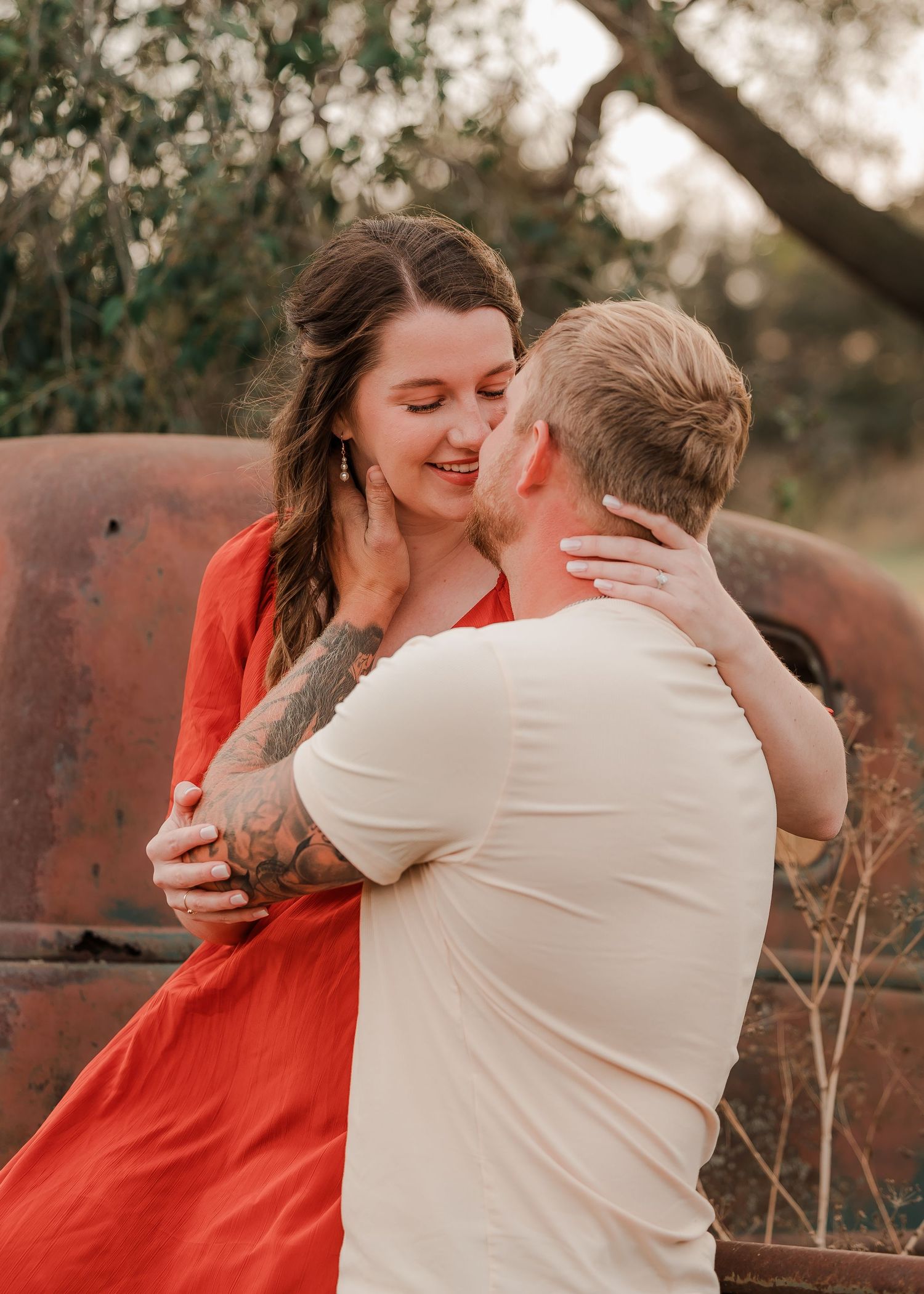 Engaged couple during fall photo session near Redfield, South Dakota with bride in red dress