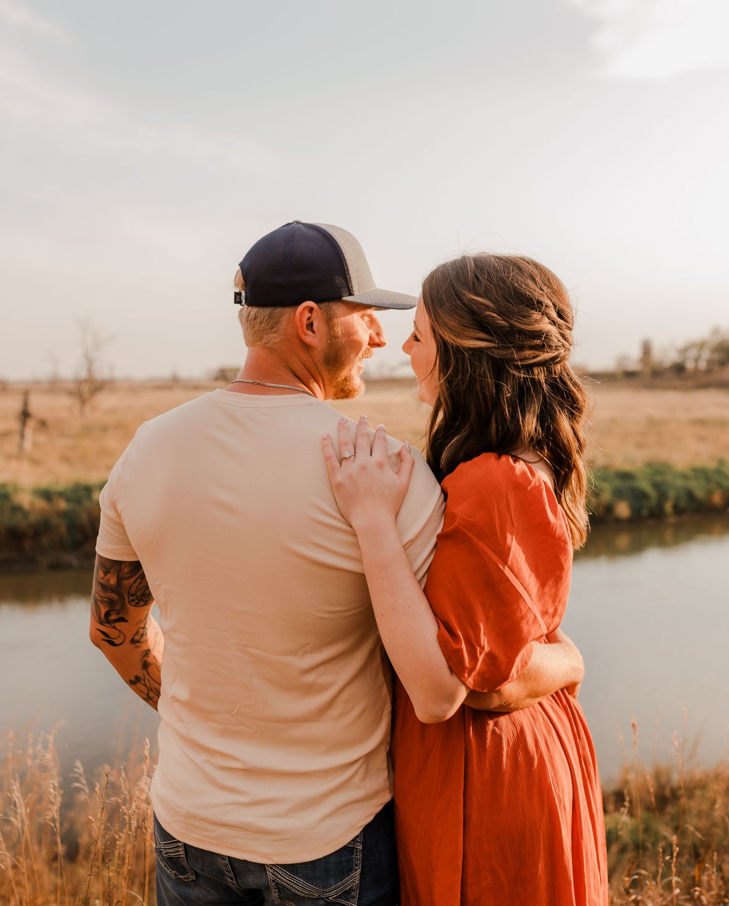 Engaged couple during fall photo session near Redfield, South Dakota with bride in red dress