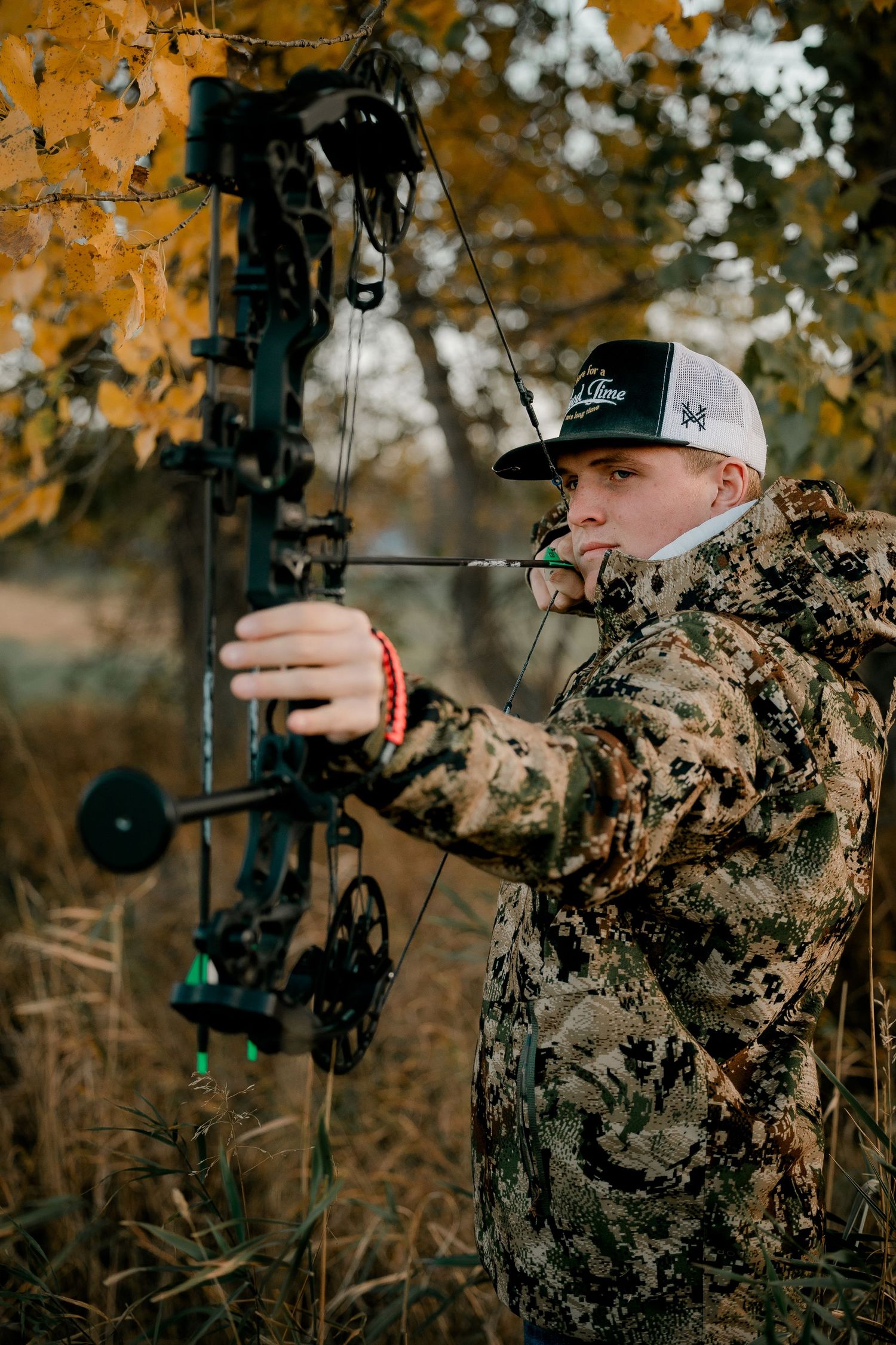 High school senior boy on family farm near Willow Lake, South Dakota with tractor and hunting gear