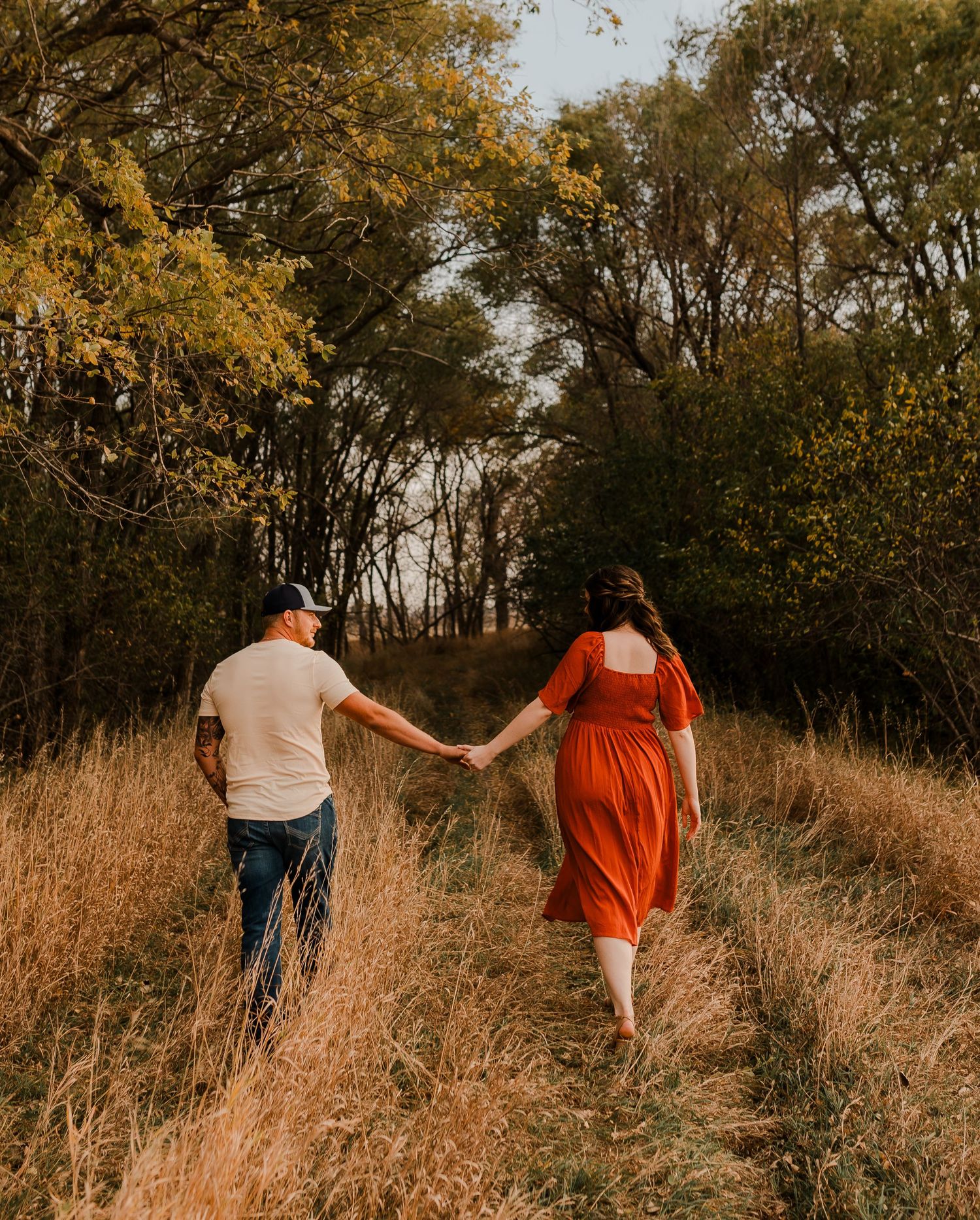 Engaged couple during fall photo session near Redfield, South Dakota with bride in red dress