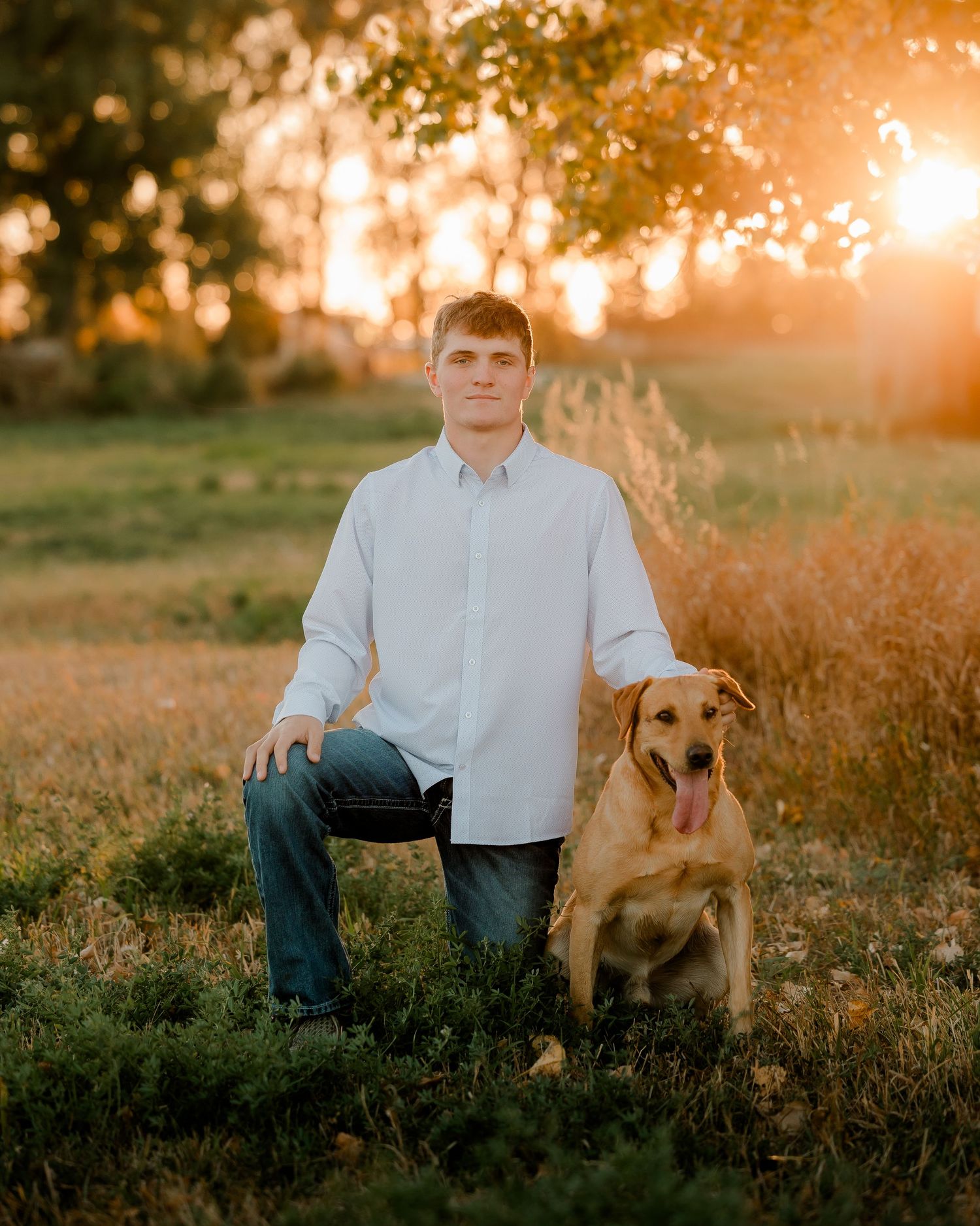 High school senior boy on family farm near Willow Lake, South Dakota with tractor and hunting gear