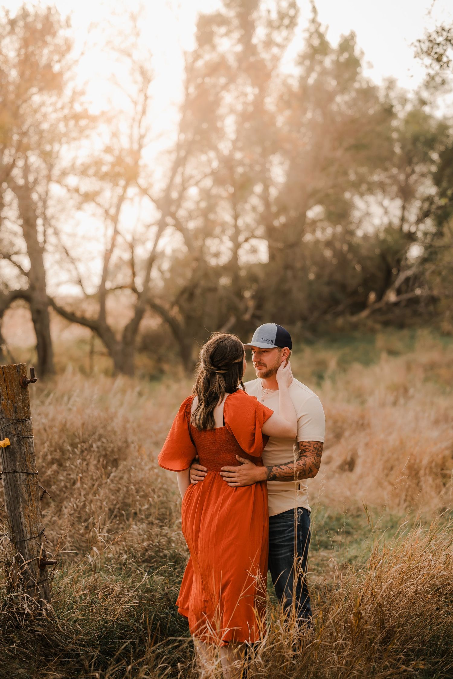 Engaged couple during fall photo session near Redfield, South Dakota with bride in red dress