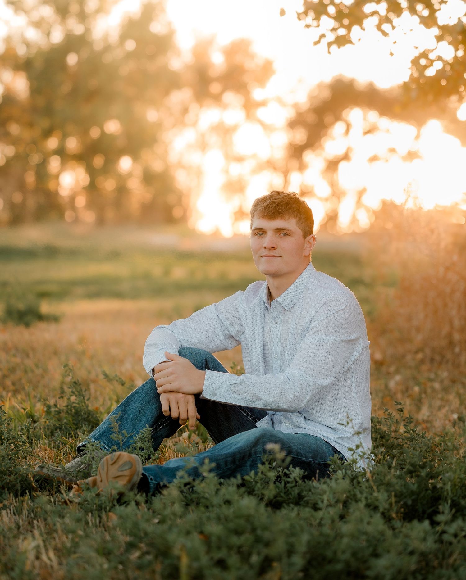 High school senior boy on family farm near Willow Lake, South Dakota with tractor and hunting gear