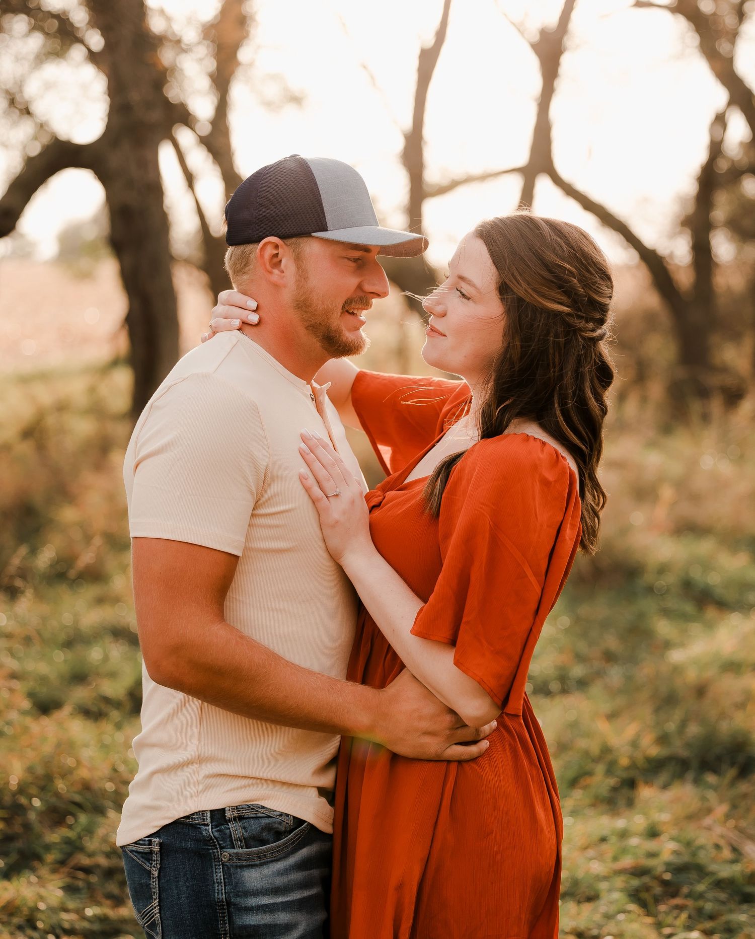 Engaged couple during fall photo session near Redfield, South Dakota with bride in red dress
