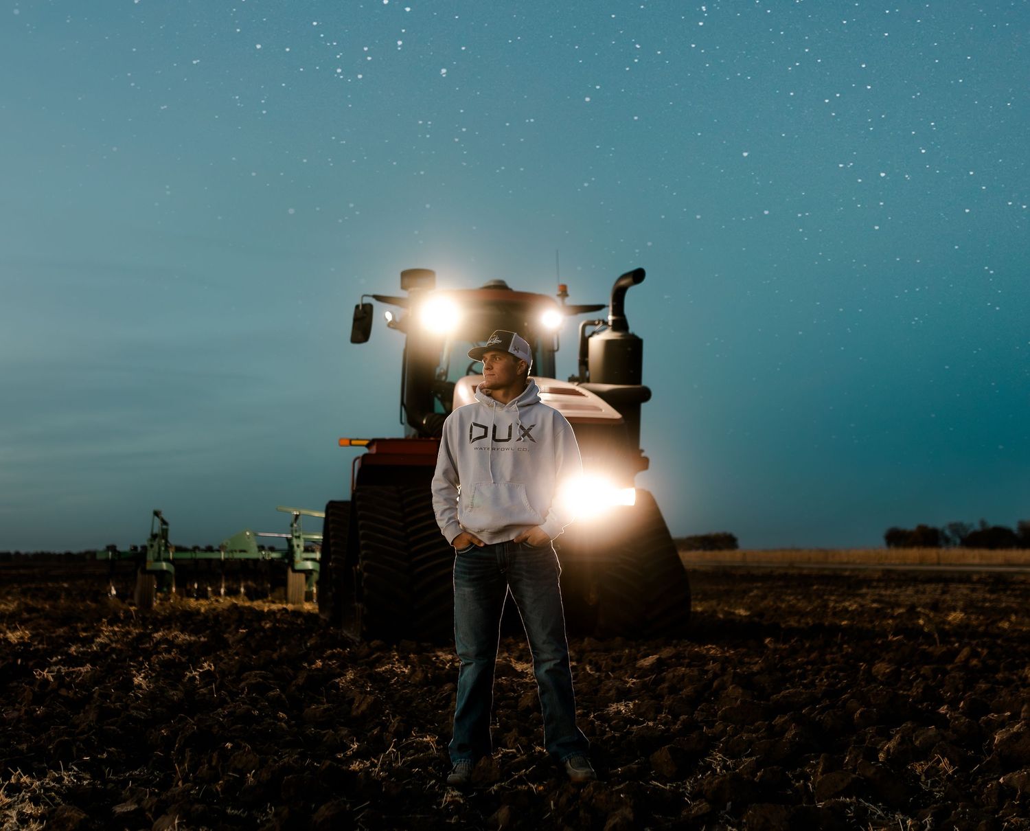 High school senior boy on family farm near Willow Lake, South Dakota with tractor and hunting gear