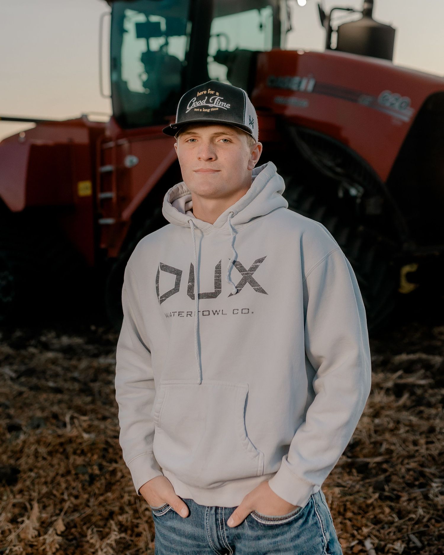 High school senior boy on family farm near Willow Lake, South Dakota with tractor and hunting gear