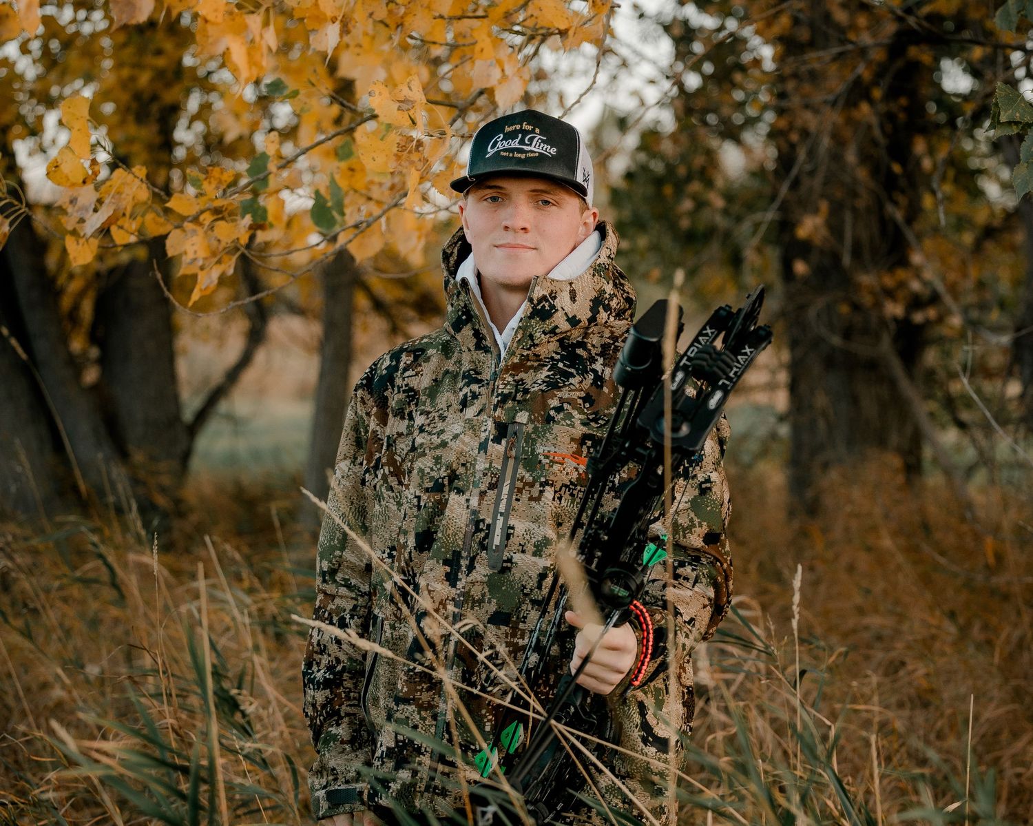 High school senior boy on family farm near Willow Lake, South Dakota with tractor and hunting gear