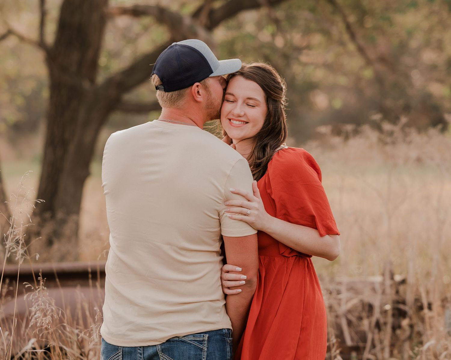 Engaged couple during fall photo session near Redfield, South Dakota with bride in red dress