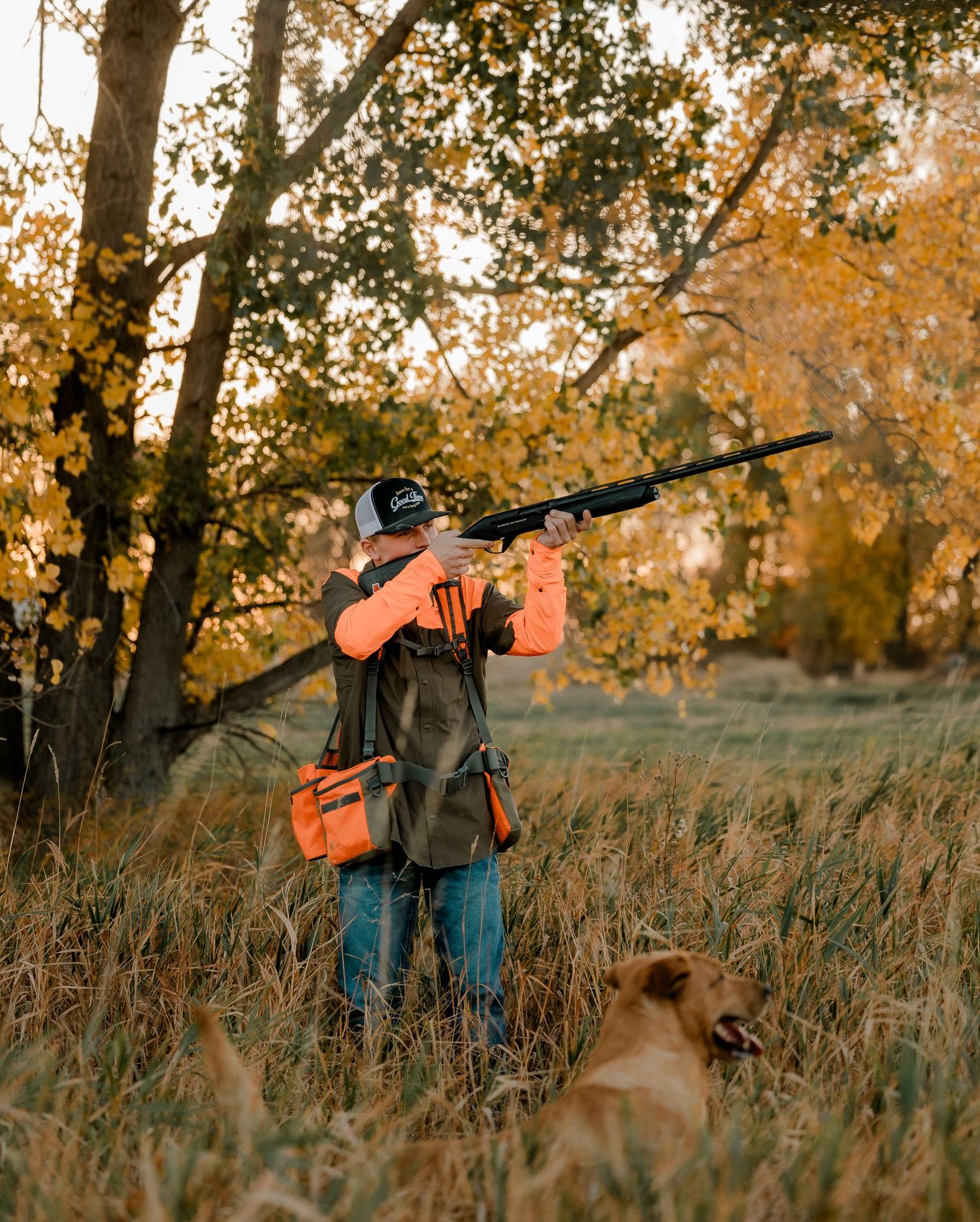 High school senior boy on family farm near Willow Lake, South Dakota with tractor and hunting gear