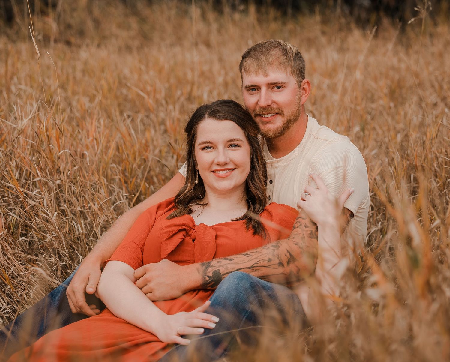 Engaged couple during fall photo session near Redfield, South Dakota with bride in red dress