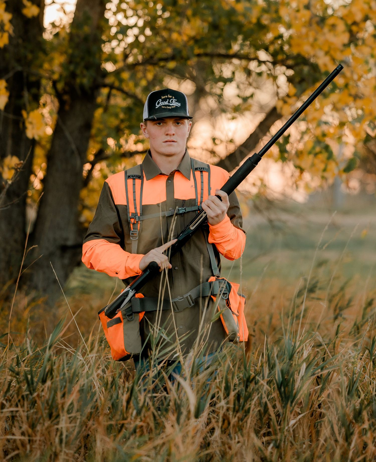 High school senior boy on family farm near Willow Lake, South Dakota with tractor and hunting gear