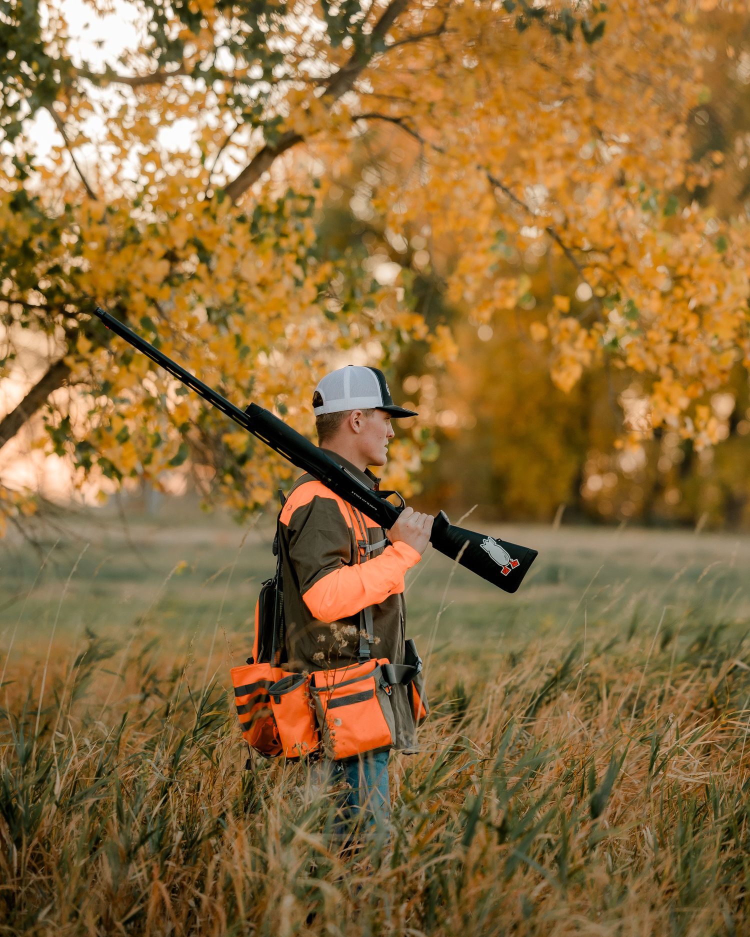High school senior boy on family farm near Willow Lake, South Dakota with tractor and hunting gear