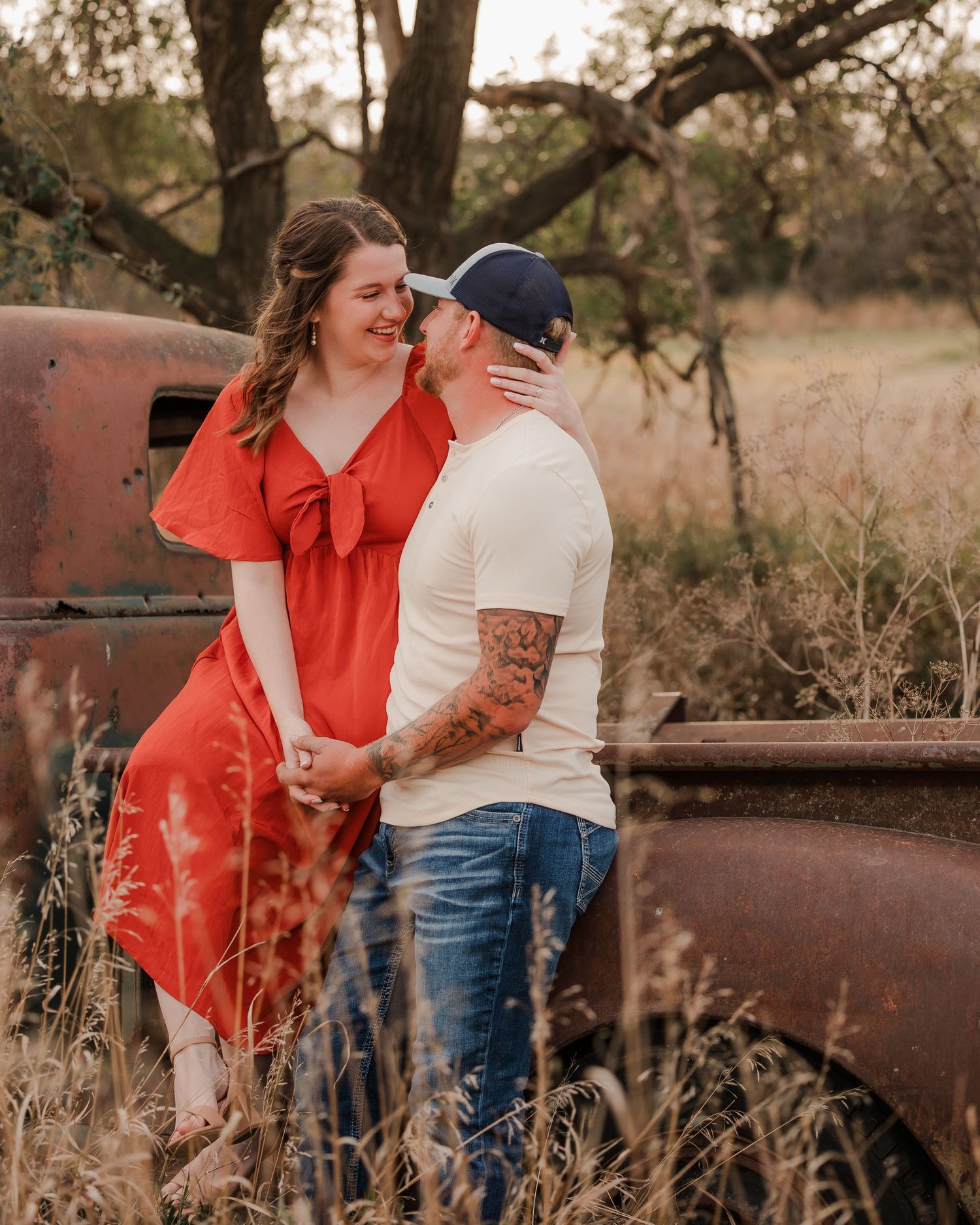 Engaged couple during fall photo session near Redfield, South Dakota with bride in red dress