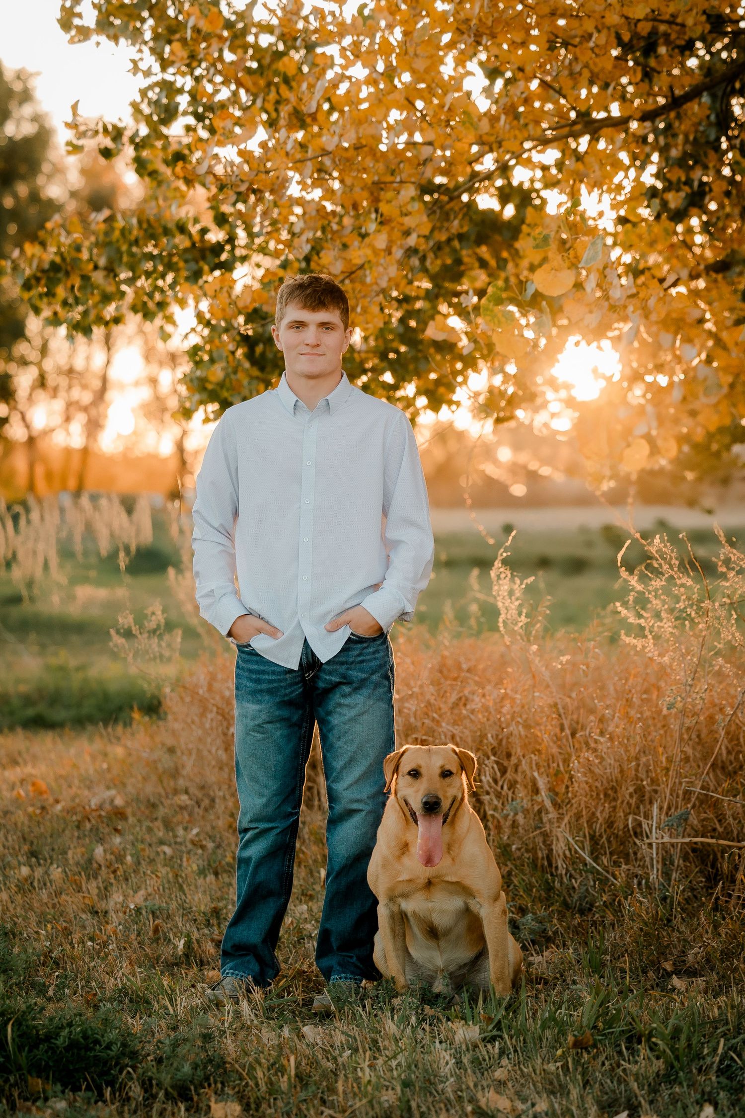 High school senior boy on family farm near Willow Lake, South Dakota with tractor and hunting gear