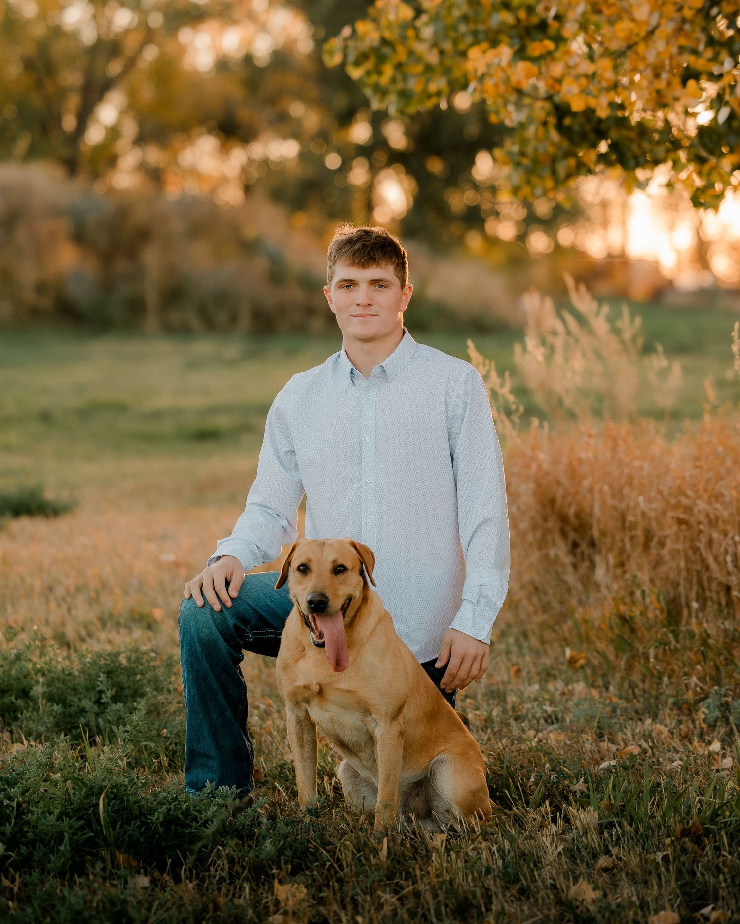 High school senior boy on family farm near Willow Lake, South Dakota with tractor and hunting gear