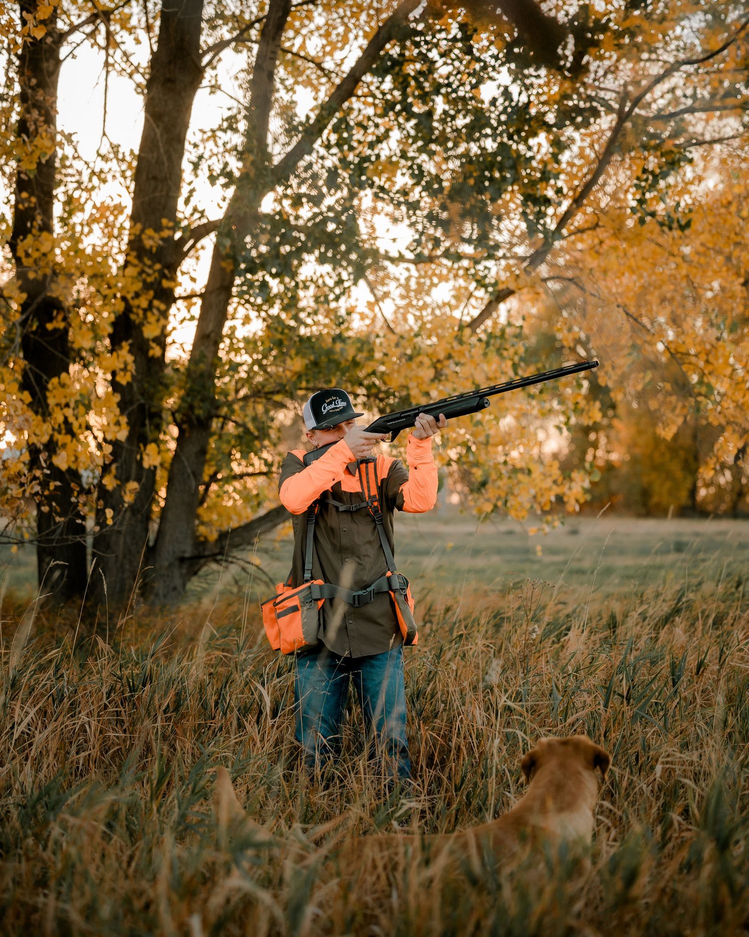High school senior boy on family farm near Willow Lake, South Dakota with tractor and hunting gear