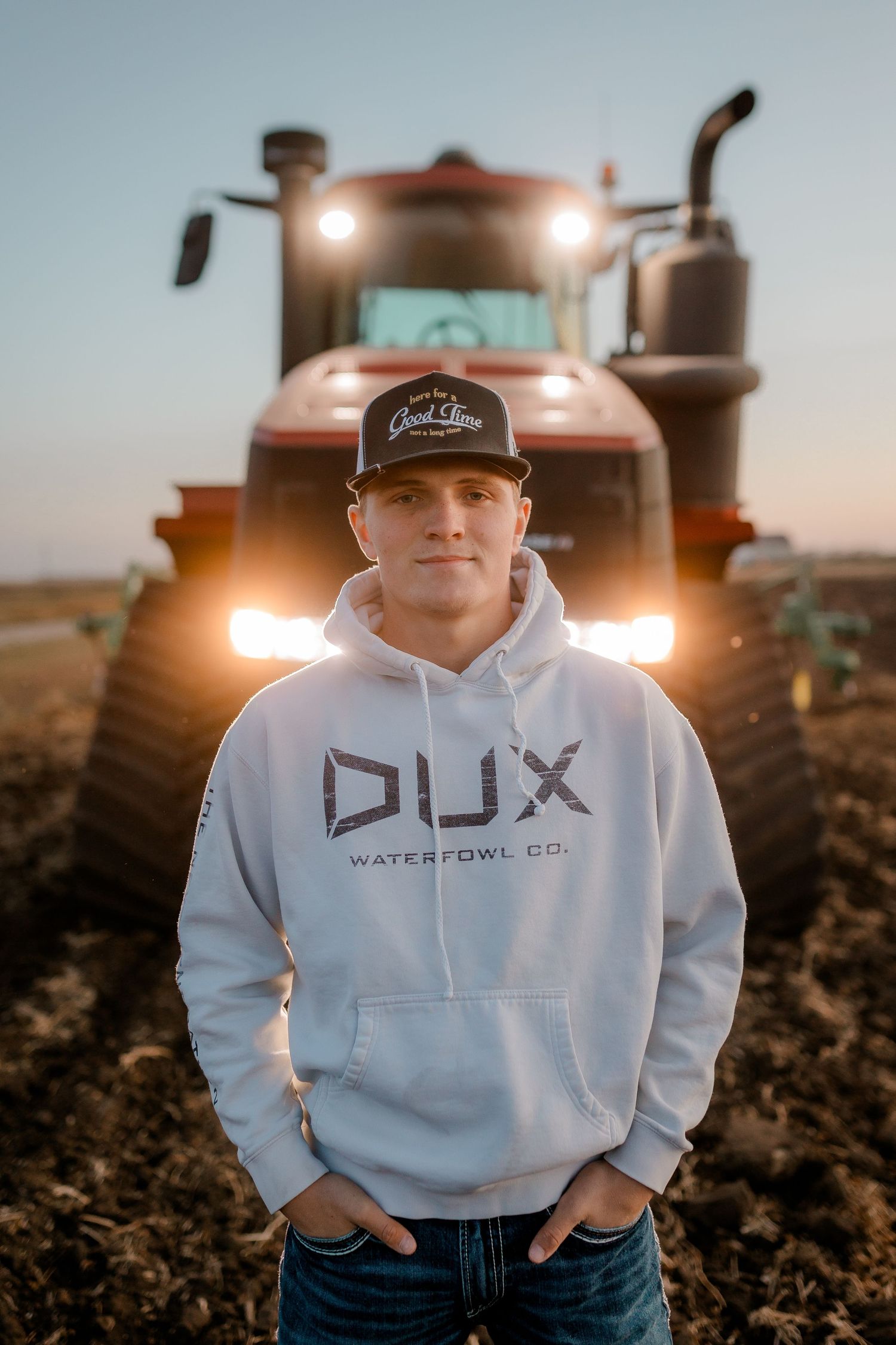 High school senior boy on family farm near Willow Lake, South Dakota with tractor and hunting gear