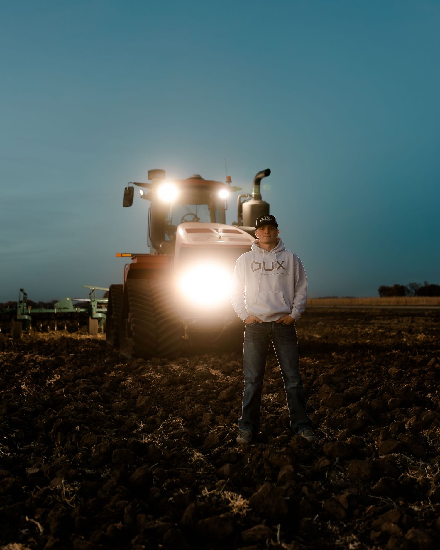 High school senior boy on family farm near Willow Lake, South Dakota with tractor and hunting gear